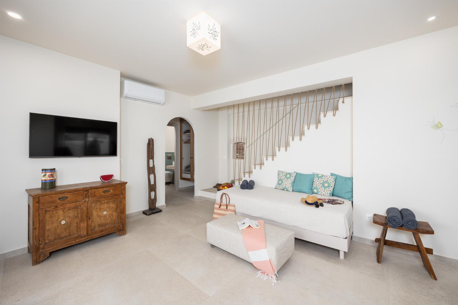 Open-plan living room with sofa, dining are, kitchen, A/C, WiFi internet, and satellite TV