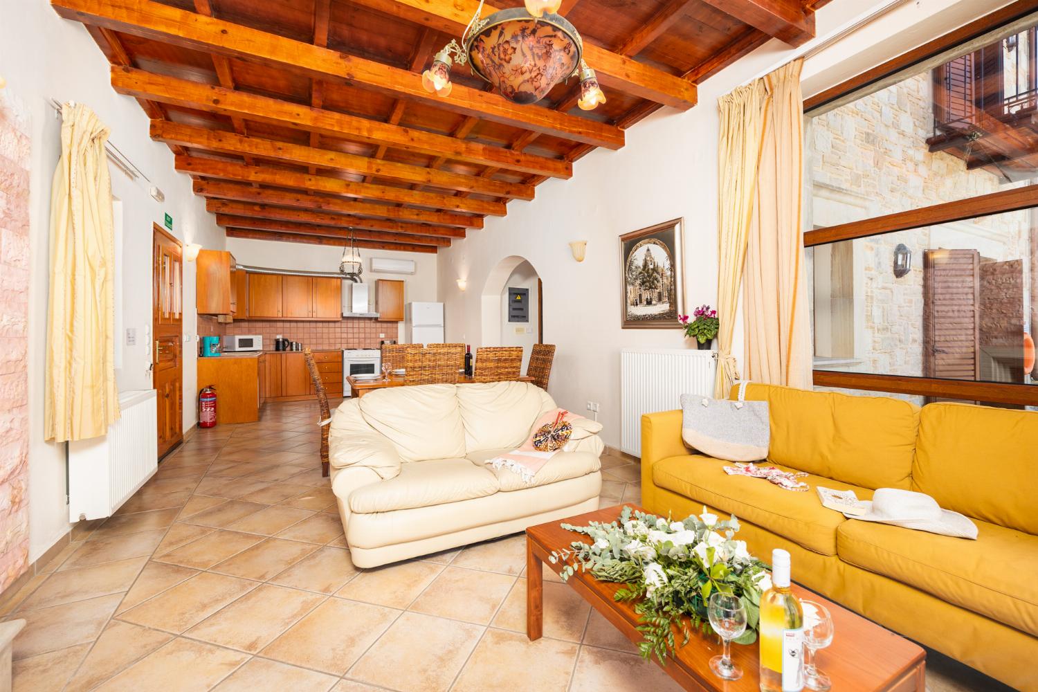 Open-plan living room with sofas, dining area, kitchen, ornamental fireplace, A/C, WiFi internet, and satellite TV