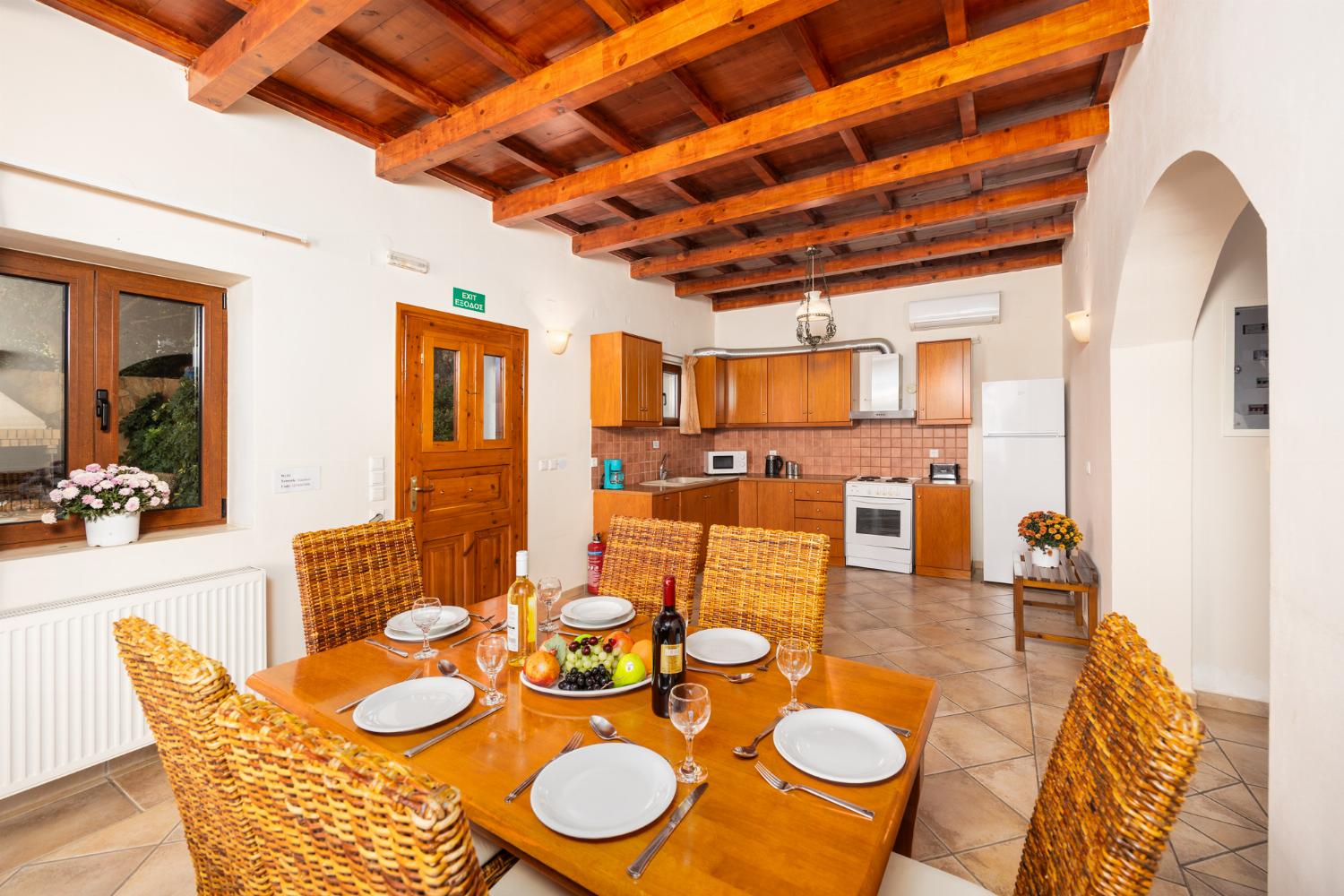 Open-plan living room with sofas, dining area, kitchen, ornamental fireplace, A/C, WiFi internet, and satellite TV