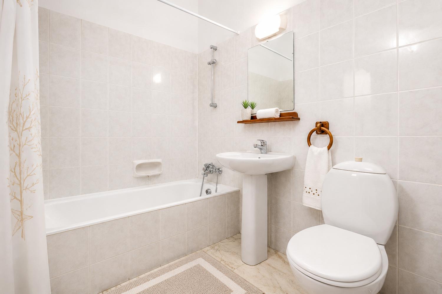 Bright bathroom with a bathtub, clean white tiling, and fresh modern touches.