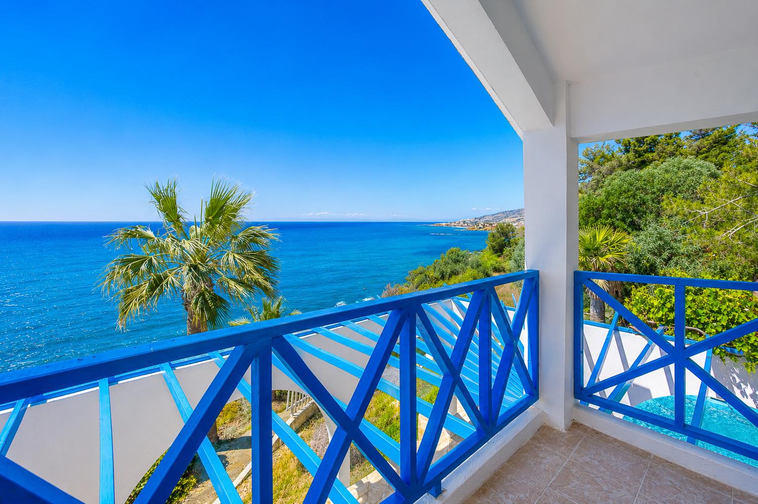 Private balcony with bright blue railings and breathtaking panoramic sea views.