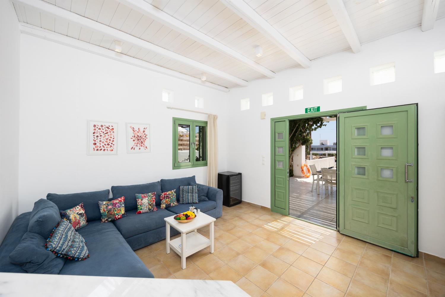 Open-plan living room with sofa, dining area, kitchen, A/C, WiFi internet, and satellite TV
