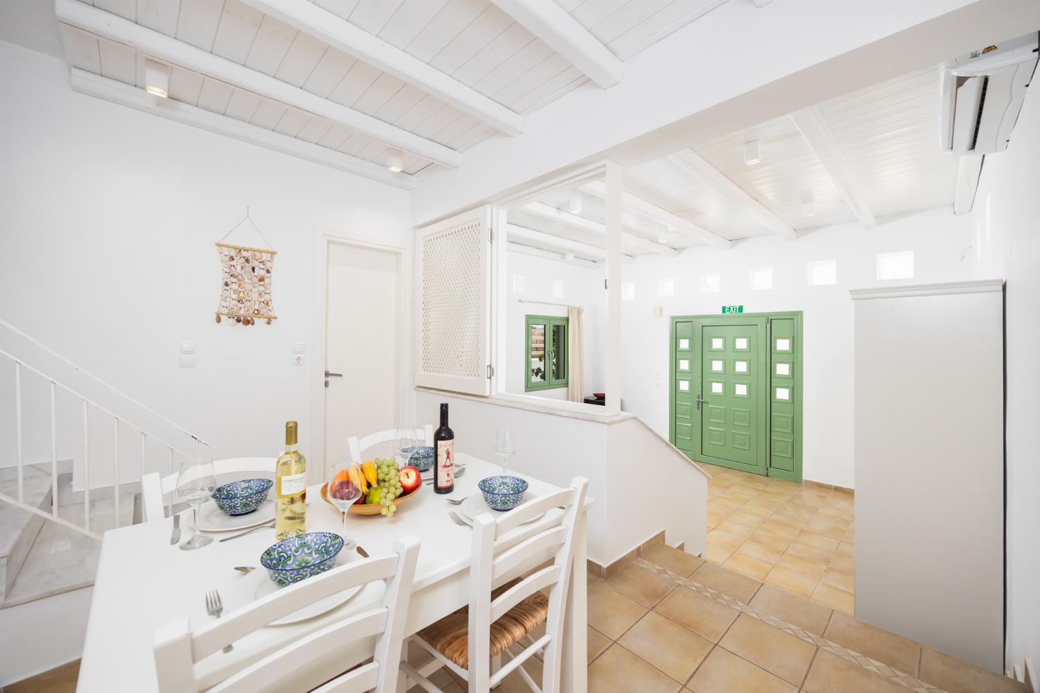 Open-plan living room with sofa, dining area, kitchen, A/C, WiFi internet, and satellite TV