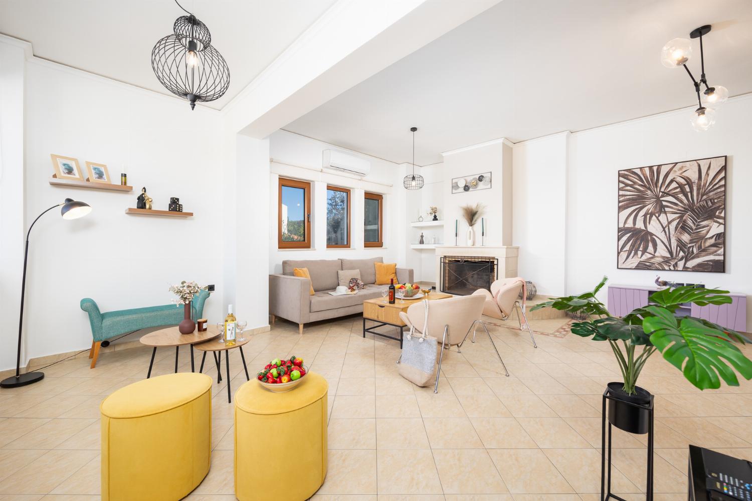 Living room with sofa, ornamental fireplace, A/C, WiFi internet, and satellite TV