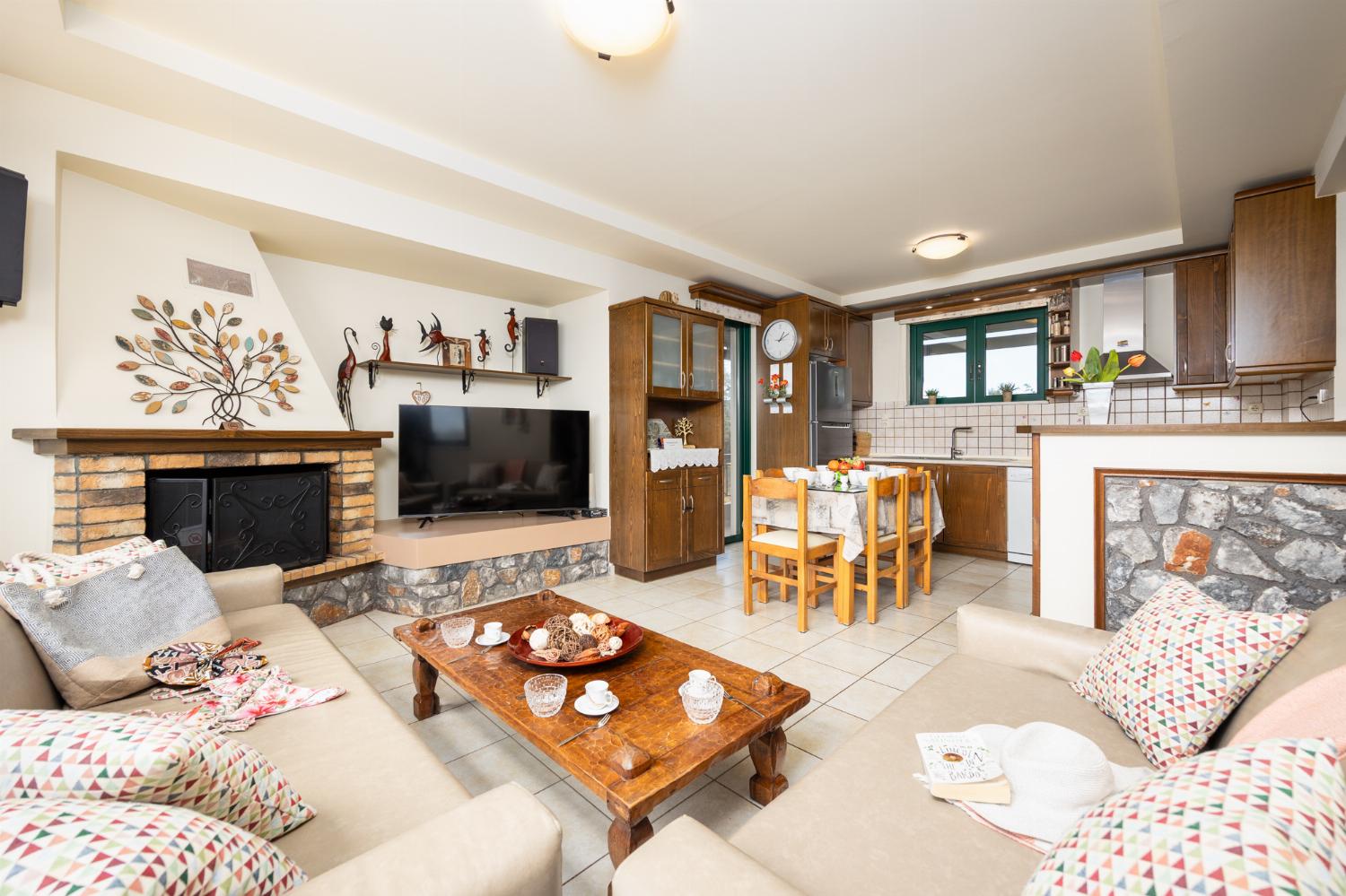 Open-plan living room with sofas, dining areas, kitchen, ornamental fireplace, A/C, WiFi internet, and satellite TV