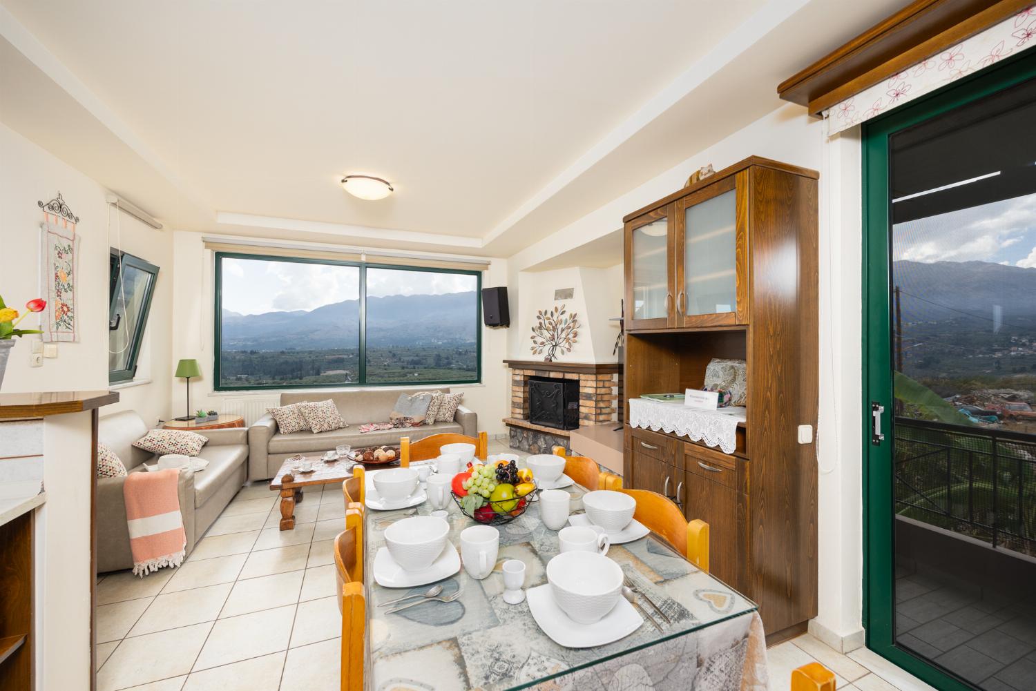 Open-plan living room with sofas, dining areas, kitchen, ornamental fireplace, A/C, WiFi internet, and satellite TV