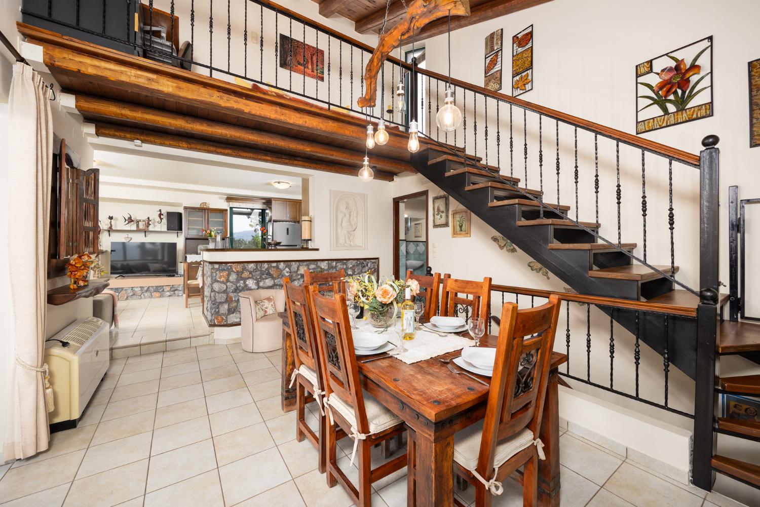 Open-plan living room with sofas, dining areas, kitchen, ornamental fireplace, A/C, WiFi internet, and satellite TV