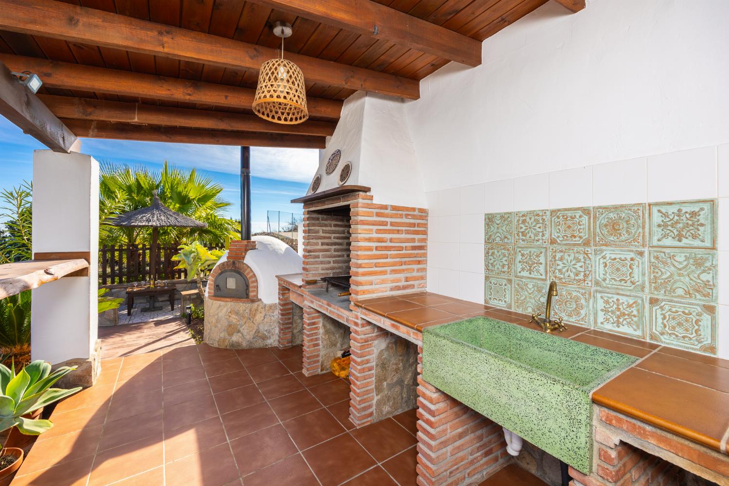 Sheltered terrace area with BBQ and wood-fired oven