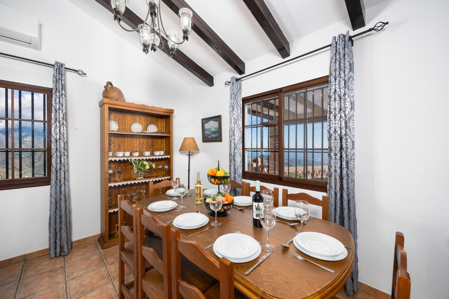 Open-plan living room with sofas, dining area, kitchen, ornamental fireplace, A/C, WiFi internet, and satellite TV