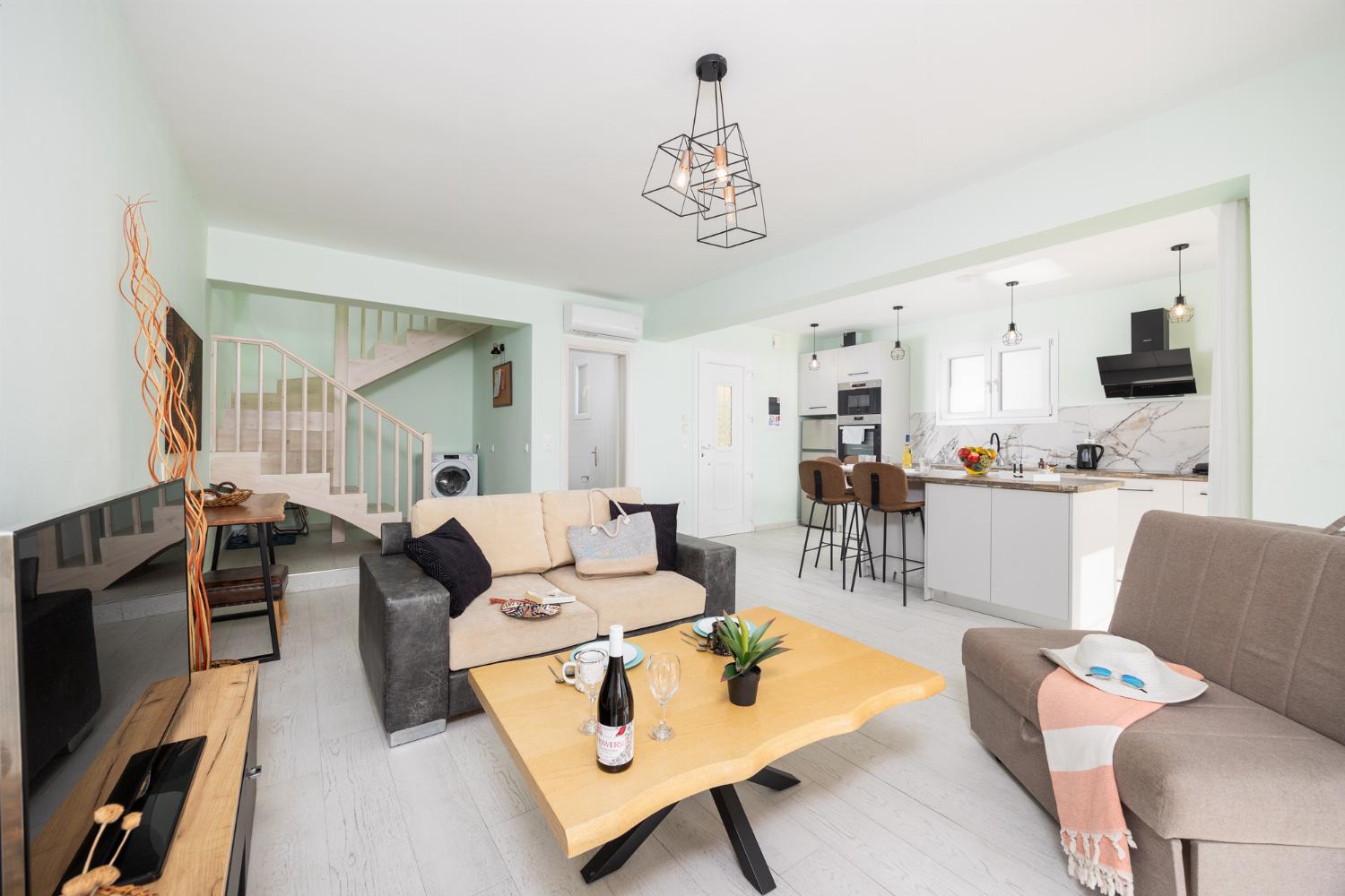 Open-plan living room with sofa, kitchen, A/C, WiFi internet, and satellite TV