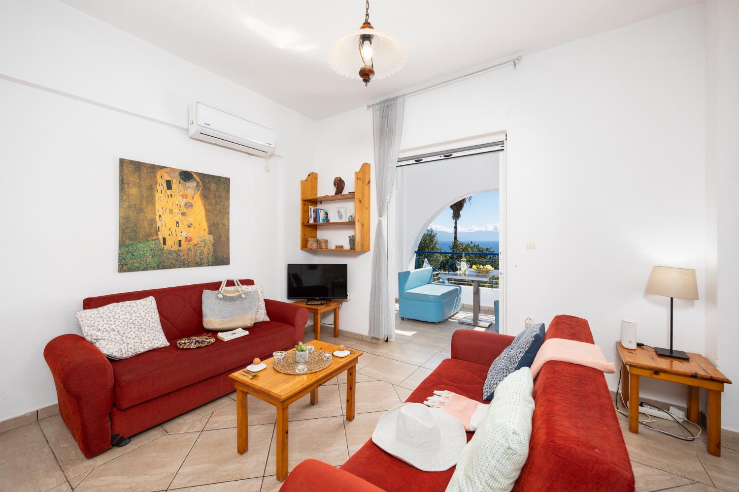 Open-plan living room with sofas, dining area, kitchen, A/C, WiFi internet, satellite TV, and sea views