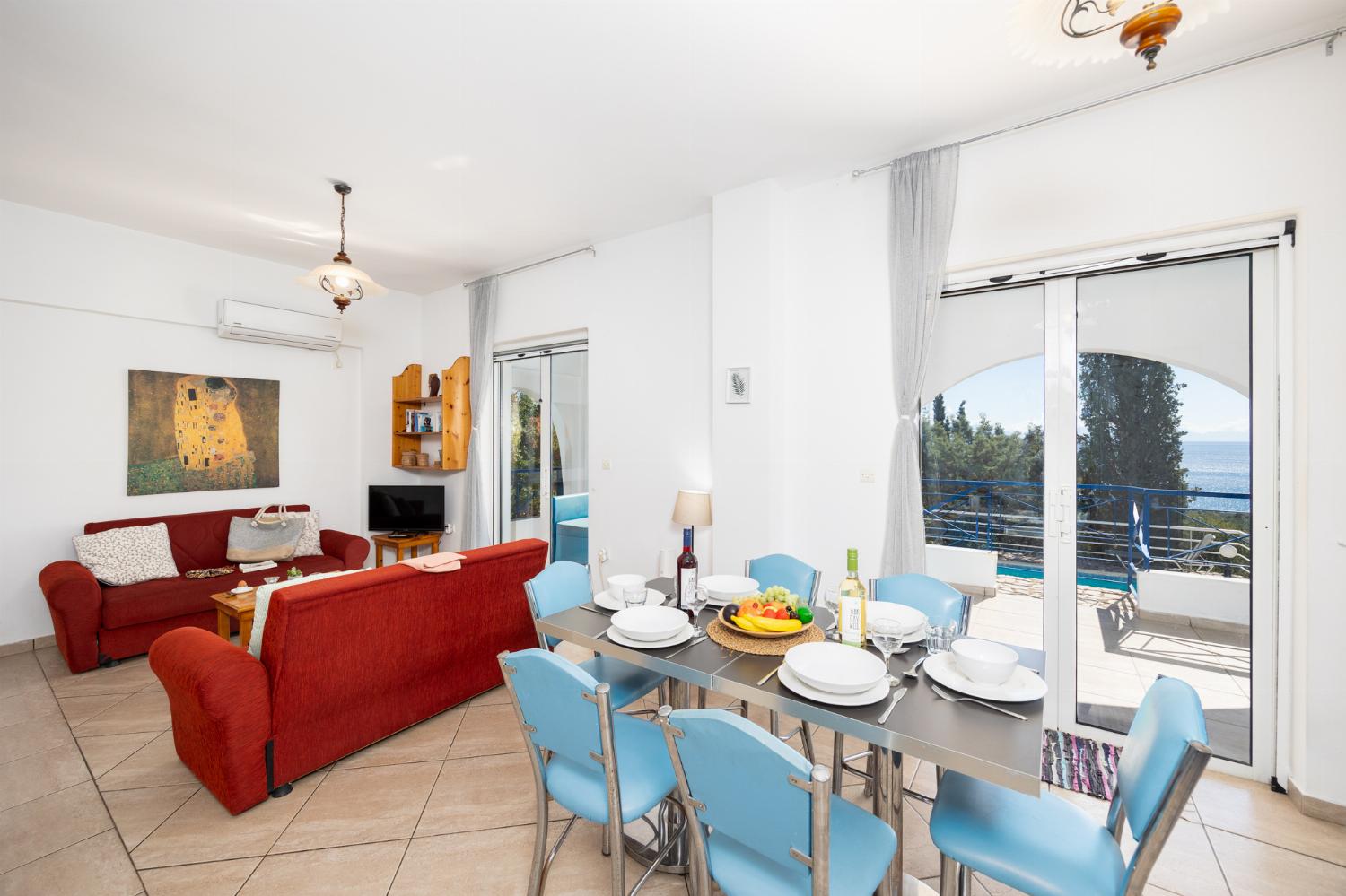 Open-plan living room with sofas, dining area, kitchen, A/C, WiFi internet, satellite TV, and sea views