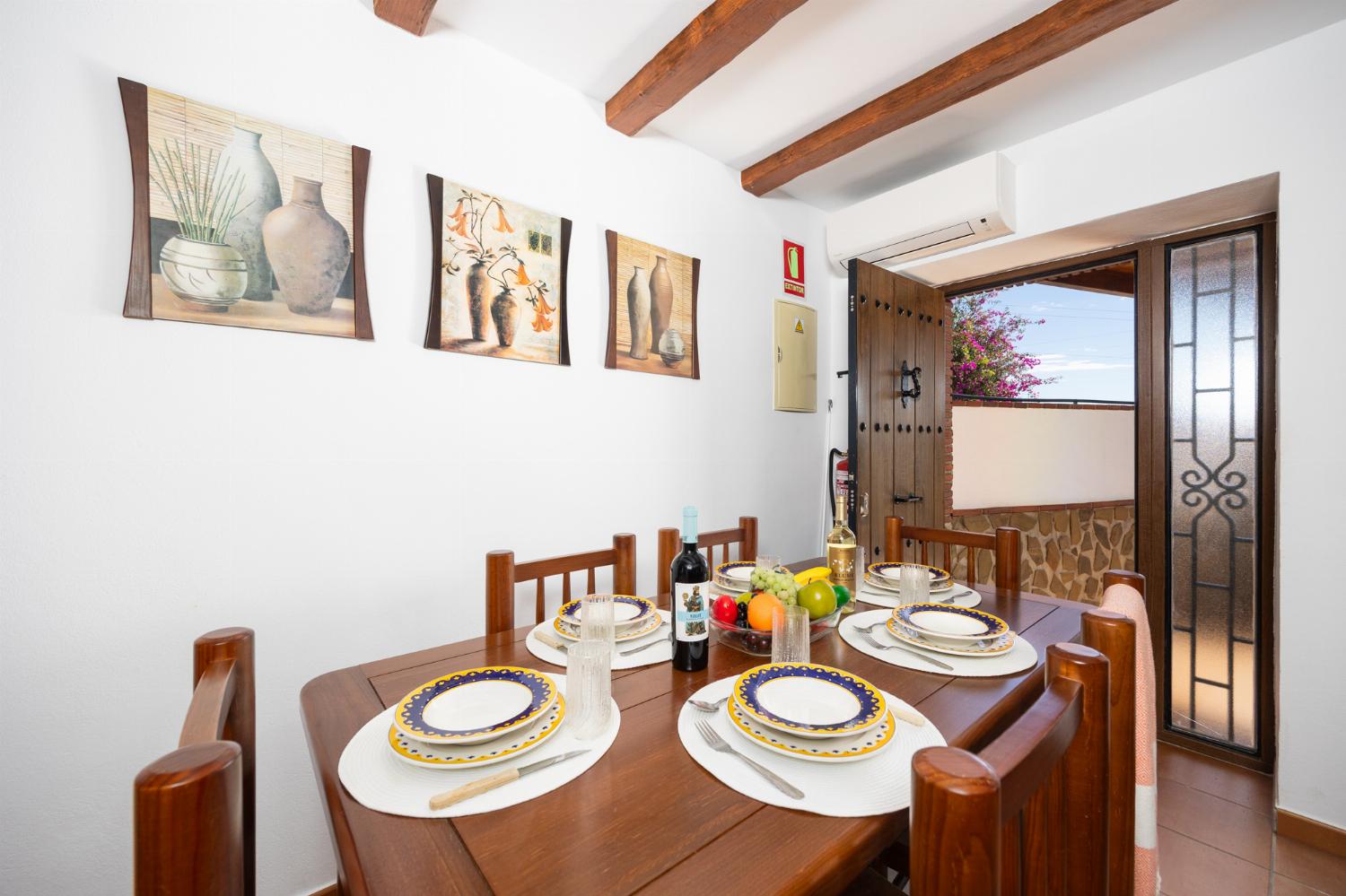 Open plan living room with sofa, dining area, kitchen, ornamental fireplace, A/C, WiFi internet, and satellite TV