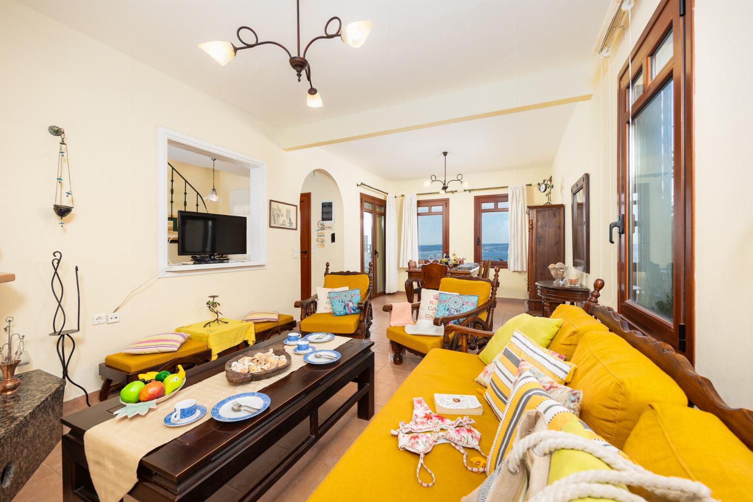 Living room with sofa, dining area, ornamental fireplace, A/C, WiFi internet, and sea views