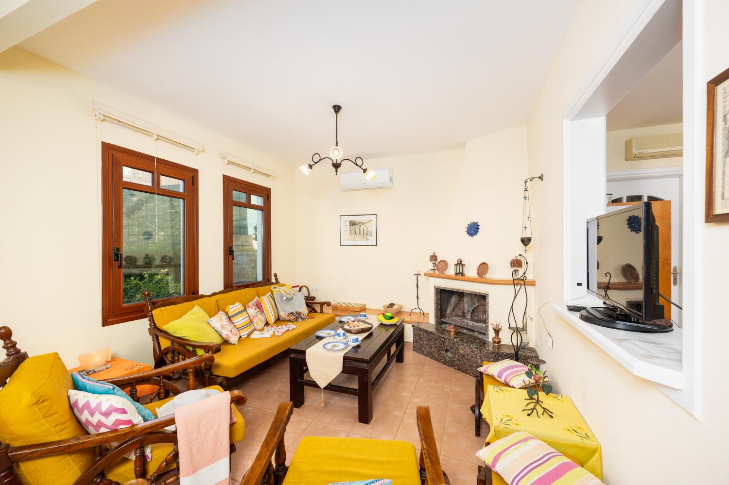 Living room with sofa, dining area, ornamental fireplace, A/C, WiFi internet, and sea views