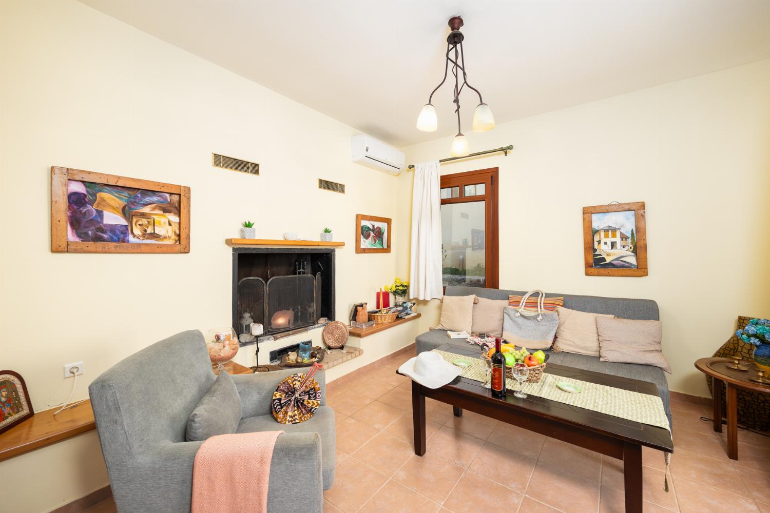Living room with sofa, ornamental fireplace, A/C, WiFi internet, and satellite TV