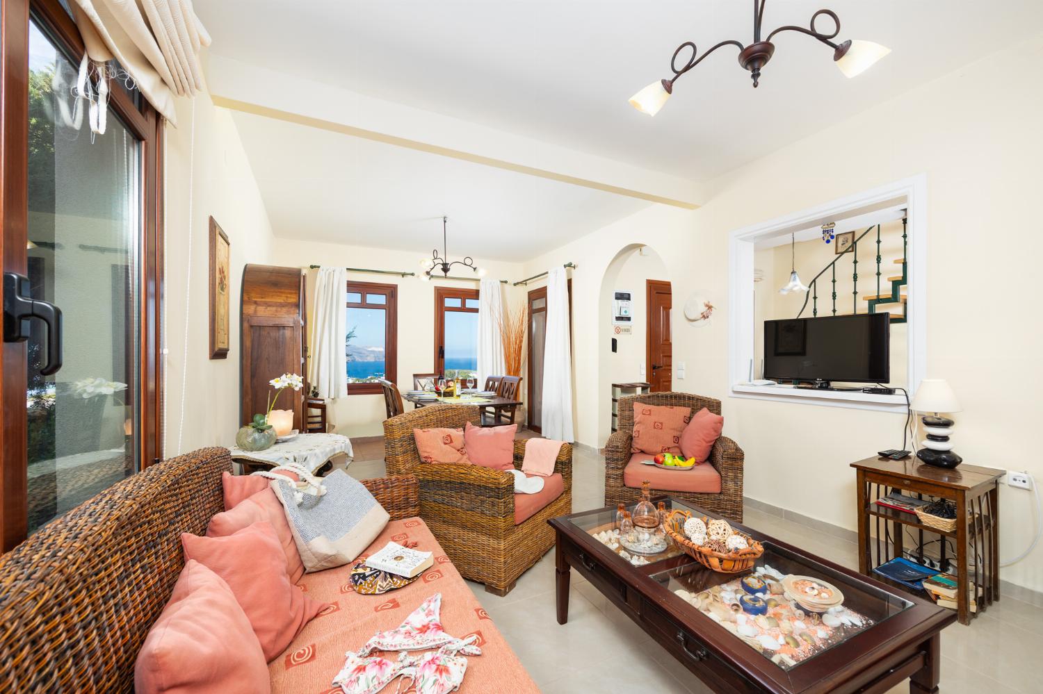 Living room with sofa, dining area, ornamental fireplace, A/C, WiFi internet, and satellite TV