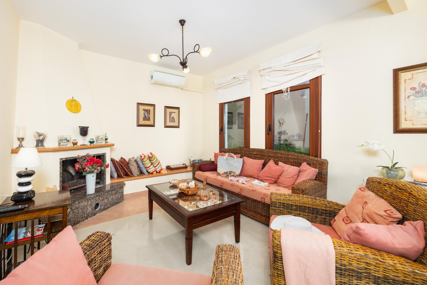 Living room with sofa, dining area, ornamental fireplace, A/C, WiFi internet, and satellite TV