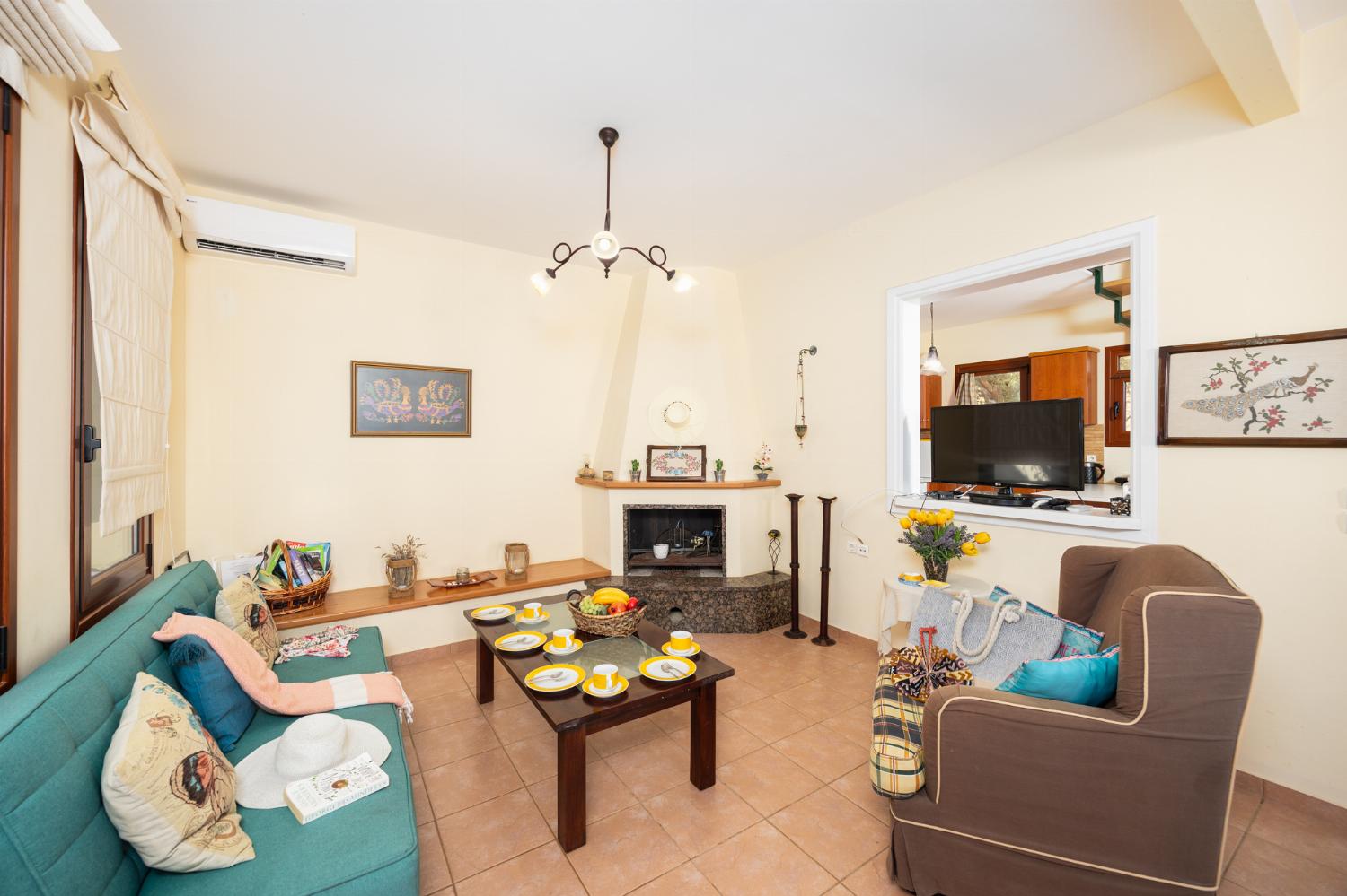 Living room with sofa, dining area, ornamental fireplace, A/C, WiFi internet, and satellite TV