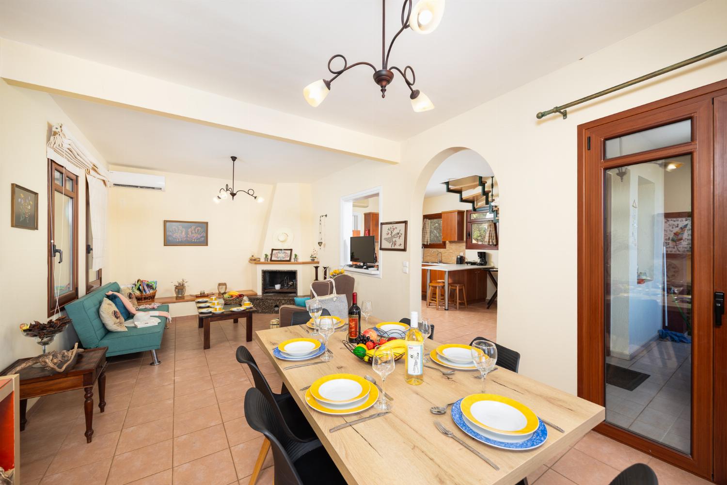 Living room with sofa, dining area, ornamental fireplace, A/C, WiFi internet, and satellite TV