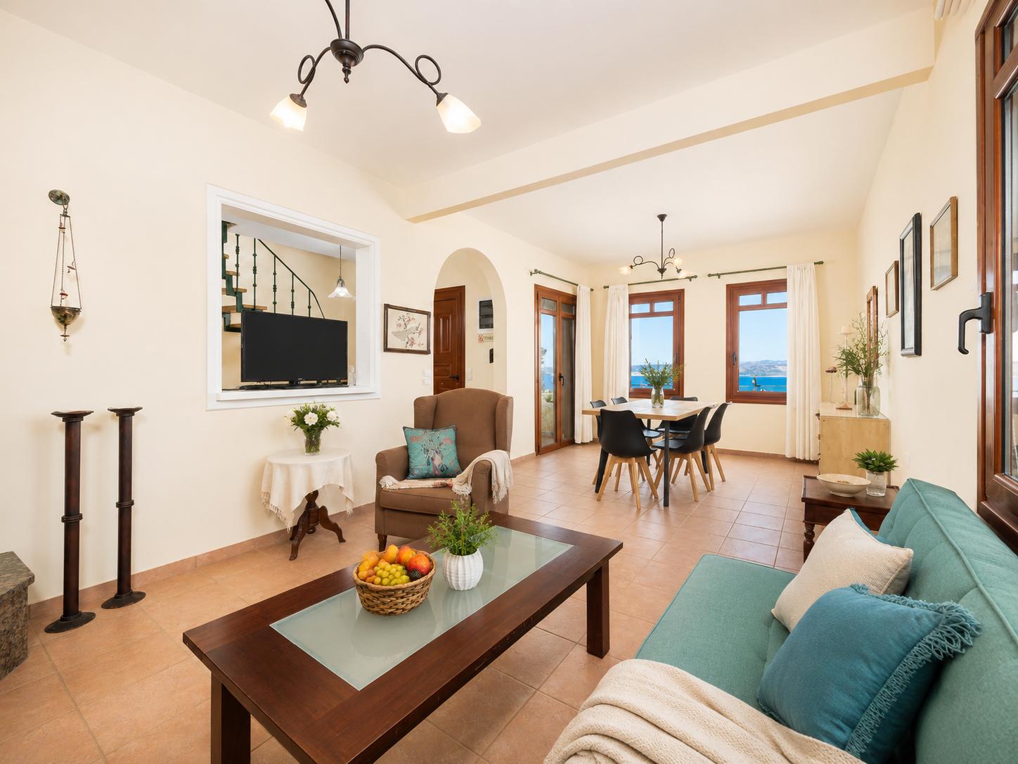 Living room with sofa, dining area, ornamental fireplace, A/C, WiFi internet, and satellite TV