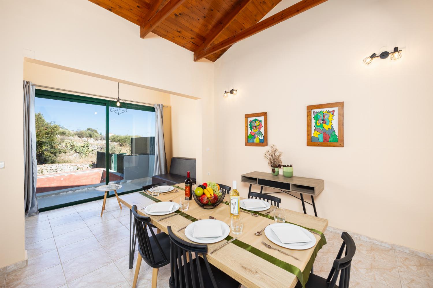 Open-plan living room with sofas, dining area, kitchen, ornamental fireplace, A/C, WiFi internet, and satellite TV