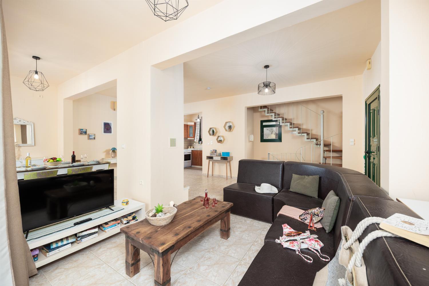 Open-plan living room with sofa, dining area, ornamental fireplace, A/C, WiFi internet, and satellite TV