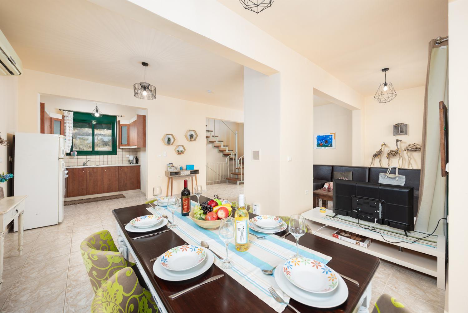 Open-plan living room with sofa, dining area, ornamental fireplace, A/C, WiFi internet, and satellite TV