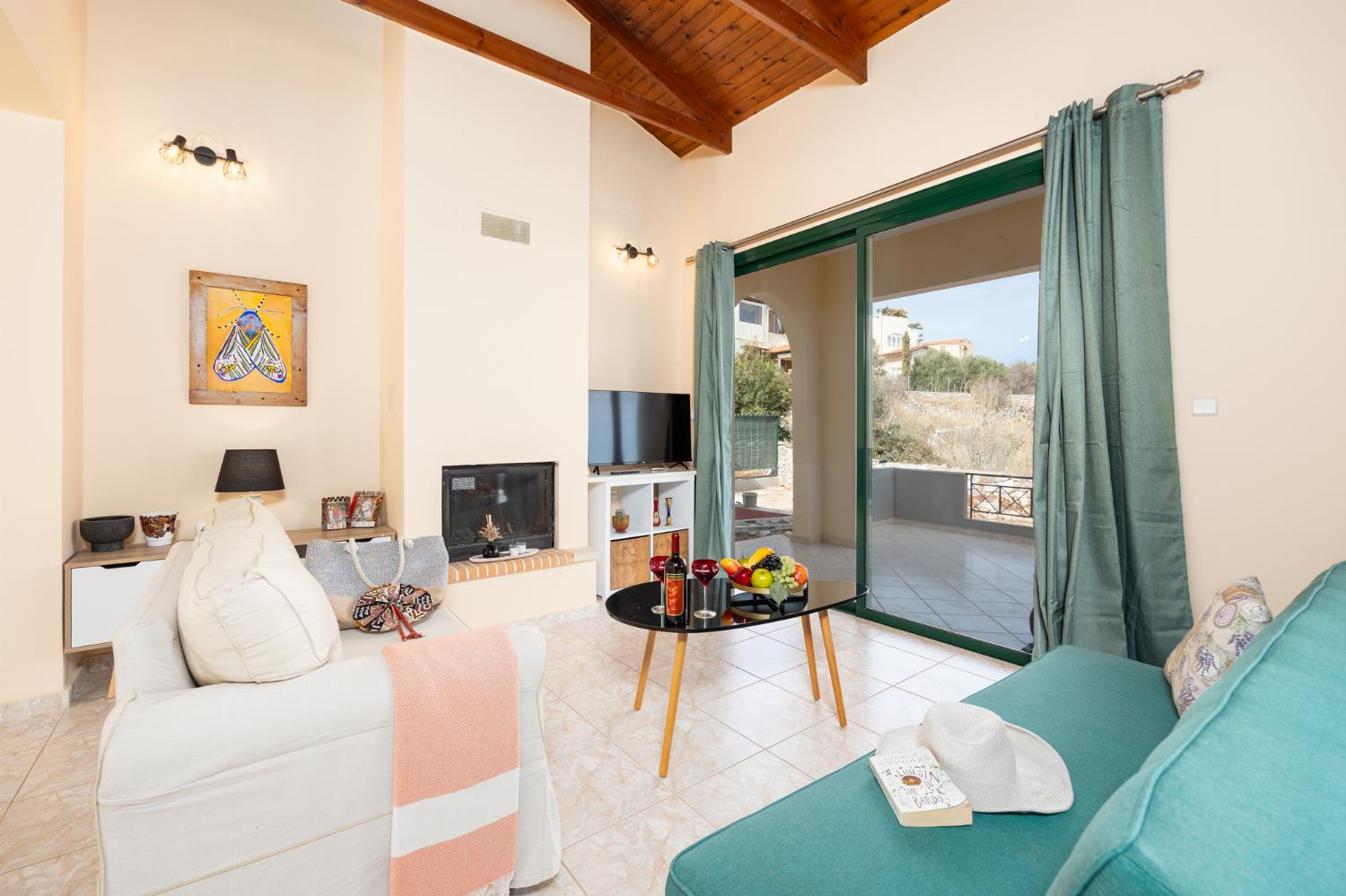 Open-plan living room with sofas, dining area, kitchen, ornamental fireplace, A/C, WiFi internet, and satellite TV