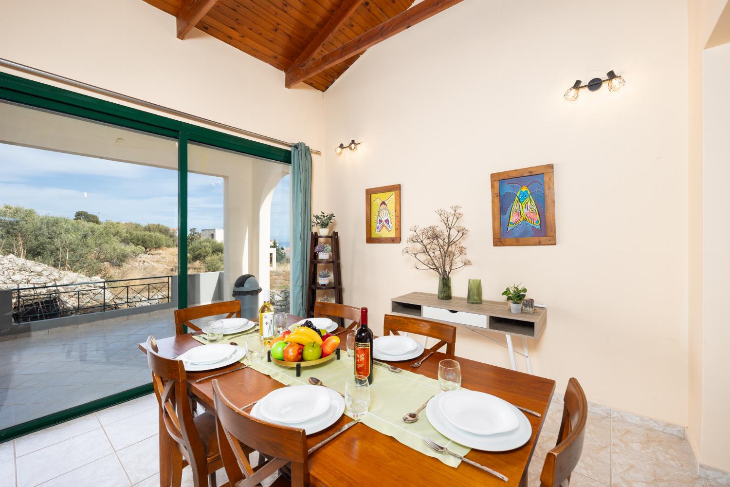 Open-plan living room with sofas, dining area, kitchen, ornamental fireplace, A/C, WiFi internet, and satellite TV