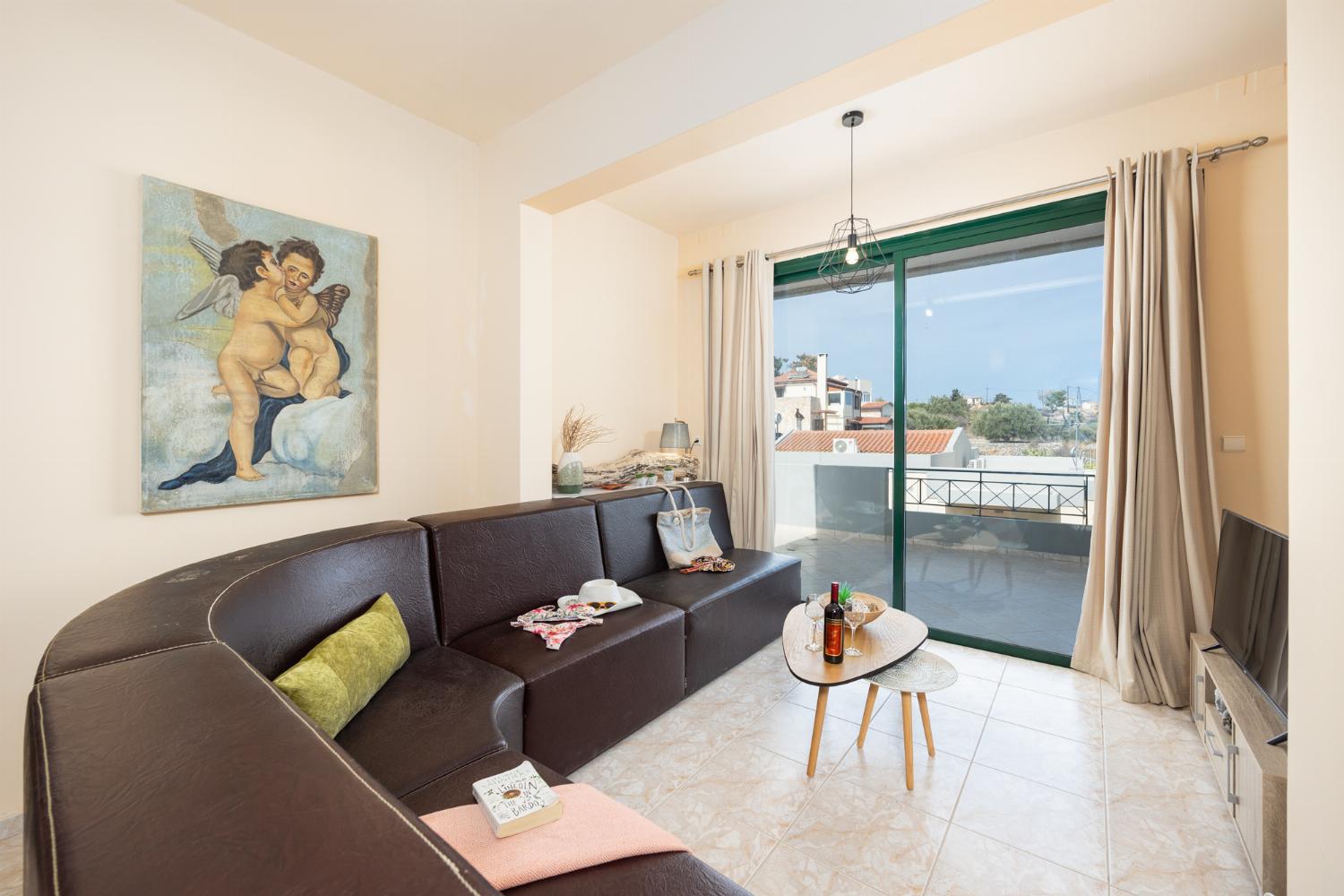 Open-plan living room with sofa, dining area, kitchen, ornamental fireplace, A/C, WiFi internet, and satellite TV