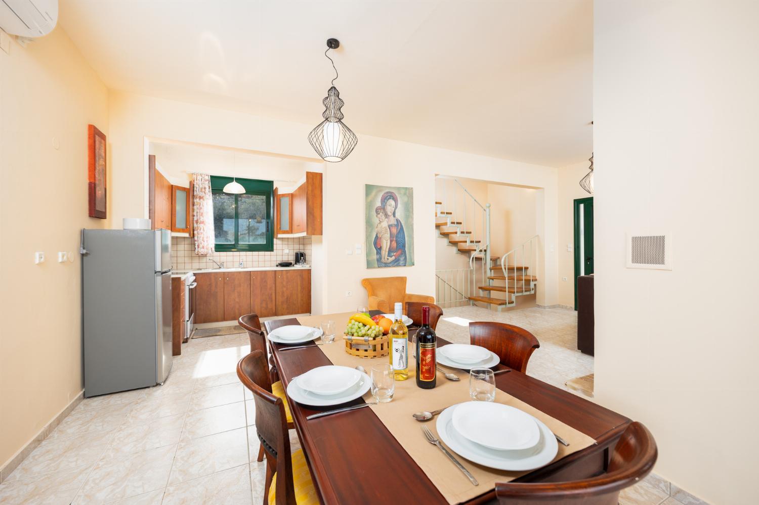 Open-plan living room with sofa, dining area, kitchen, ornamental fireplace, A/C, WiFi internet, and satellite TV