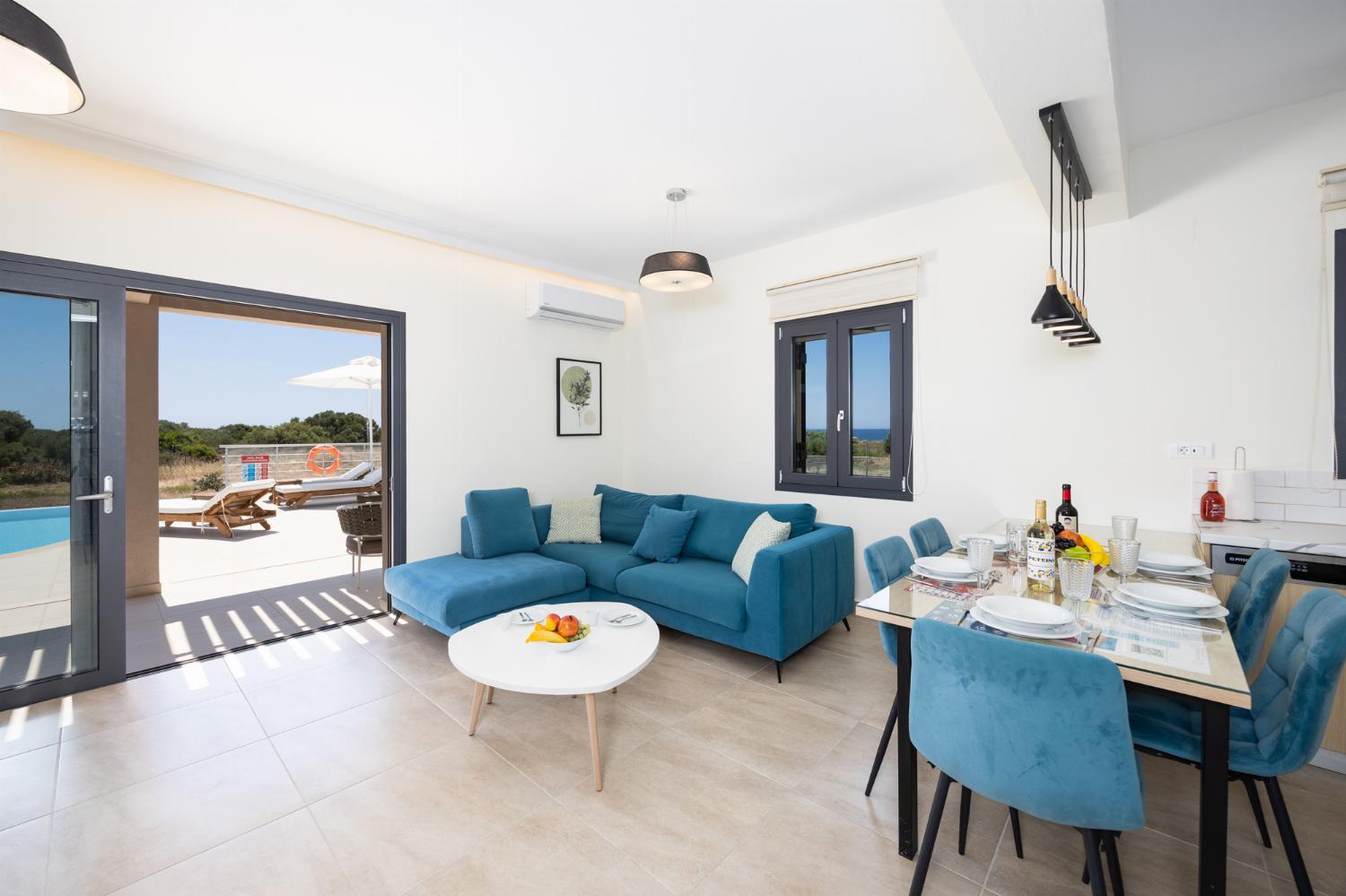 Open-plan living room with sofa, dining area, kitchen, A/C, WiFi internet, and satellite TV