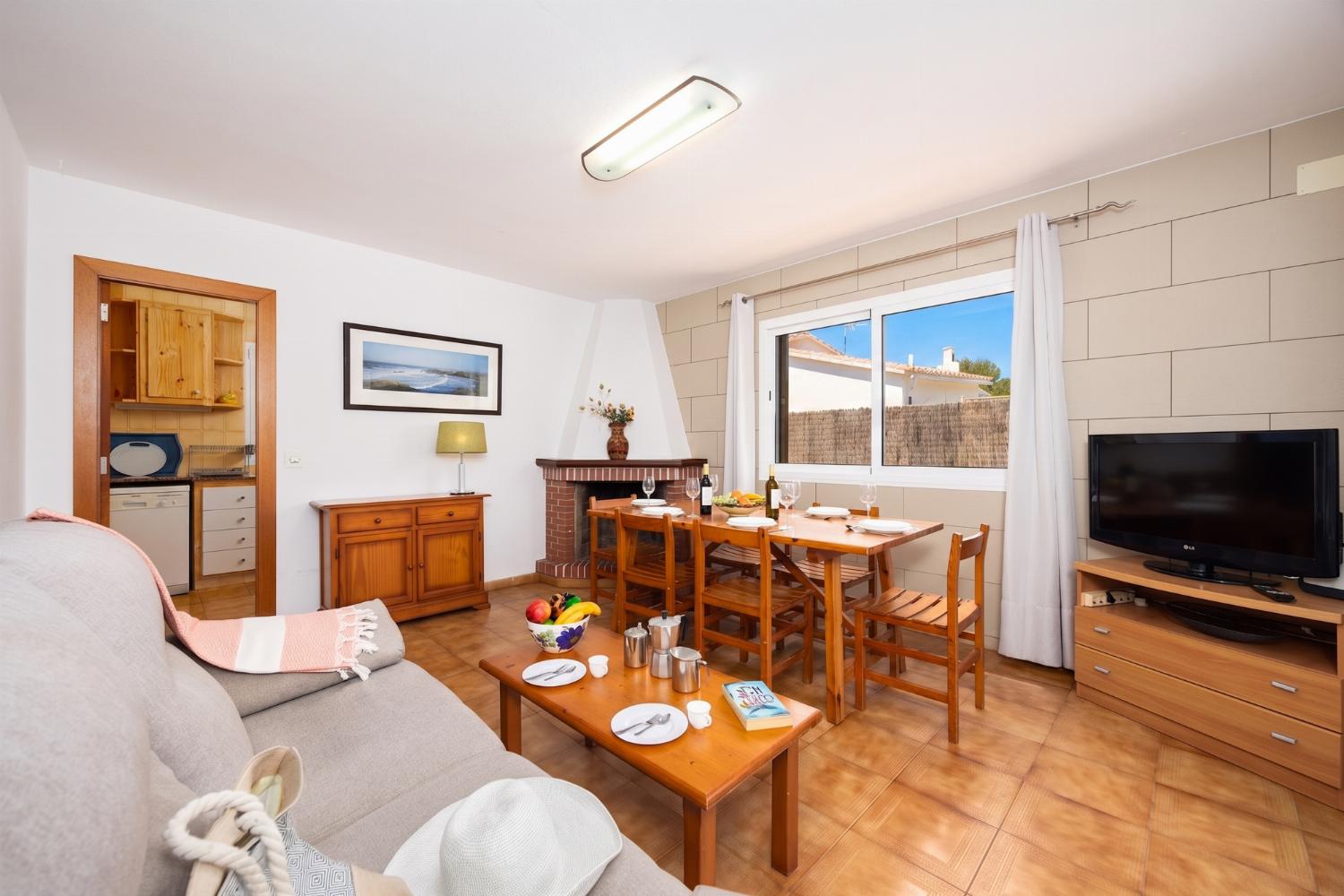 Living room with sofa, dining area, ornamental fireplace, WiFi internet, and satellite TV
