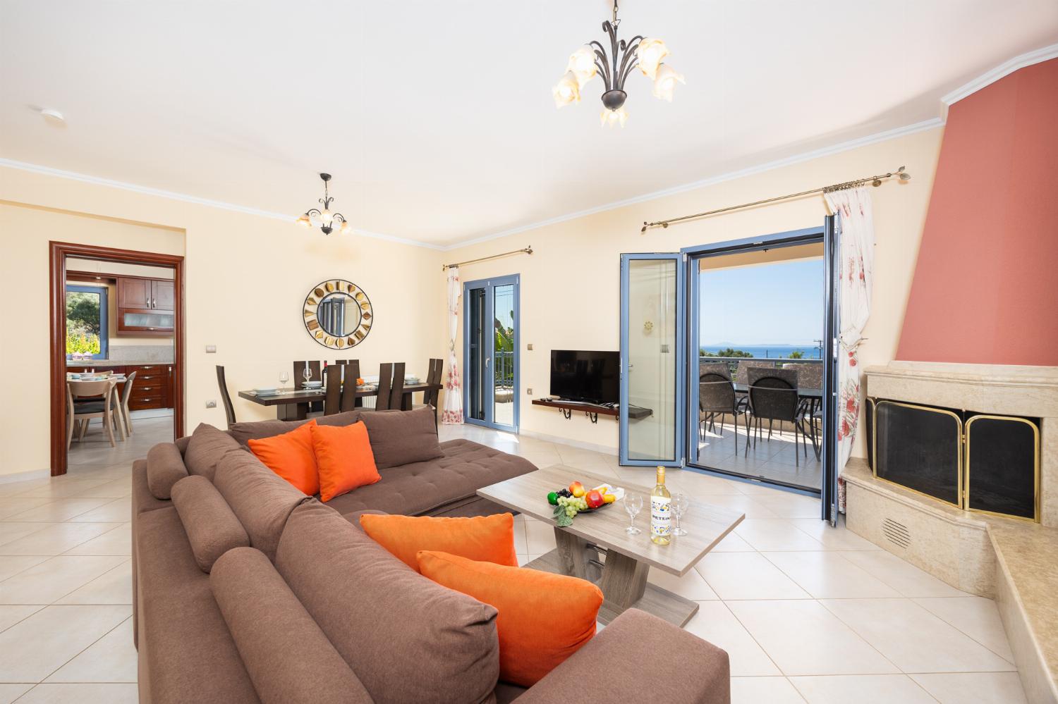 Living room with sofa, dining area, ornamental fireplace, A/C, WiFi internet, and satellite TV