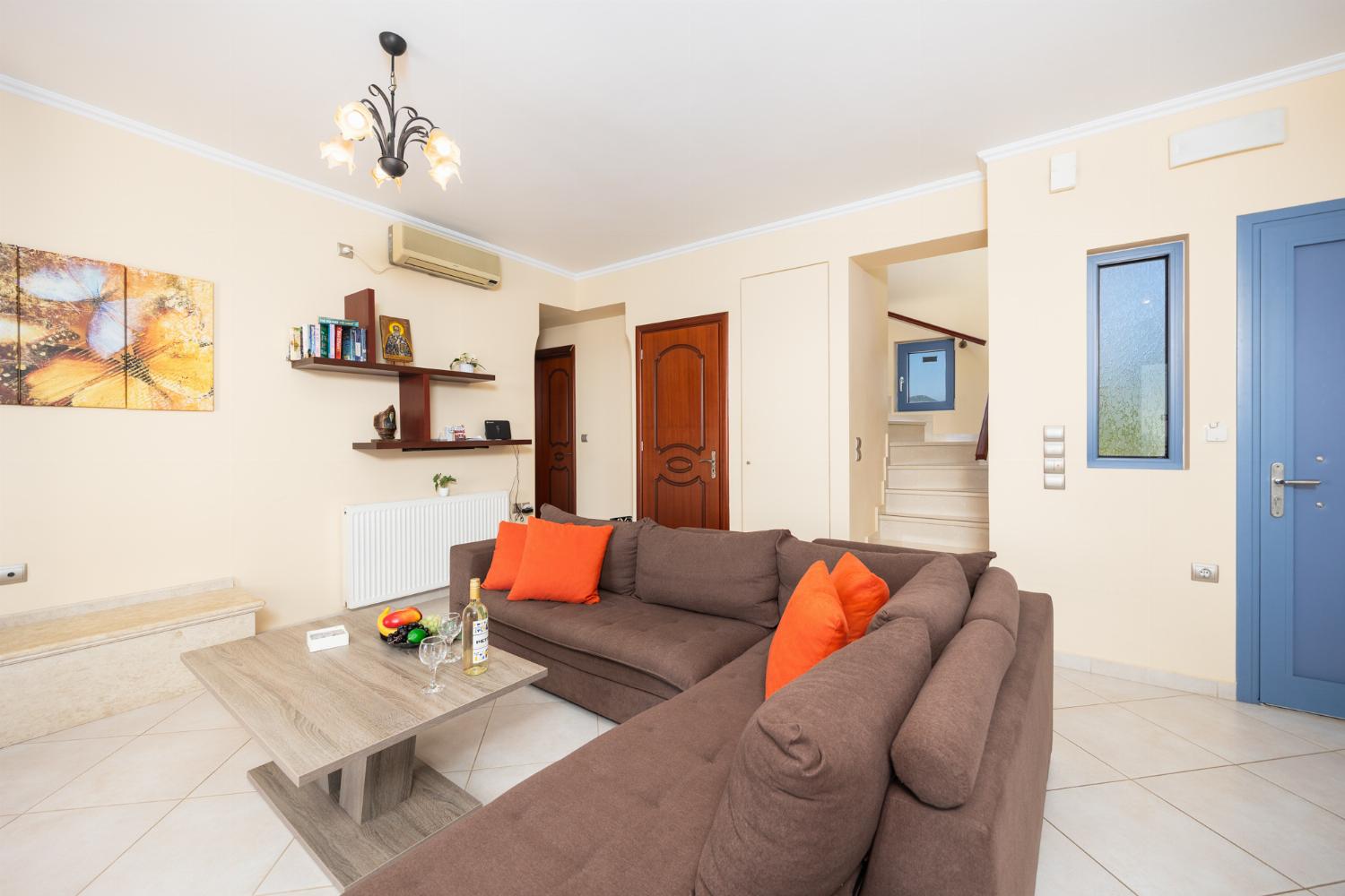 Living room with sofa, dining area, ornamental fireplace, A/C, WiFi internet, and satellite TV