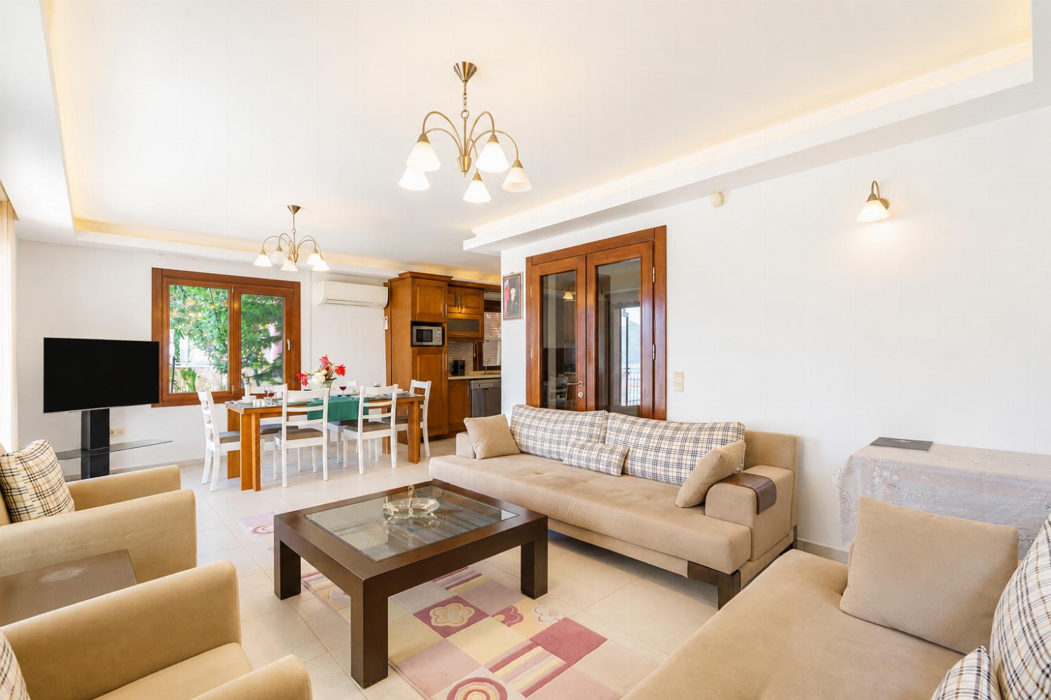 Open-plan living room with sofas, dining area, kitchen, A/C, WiFi internet, satellite TV, and sea views
