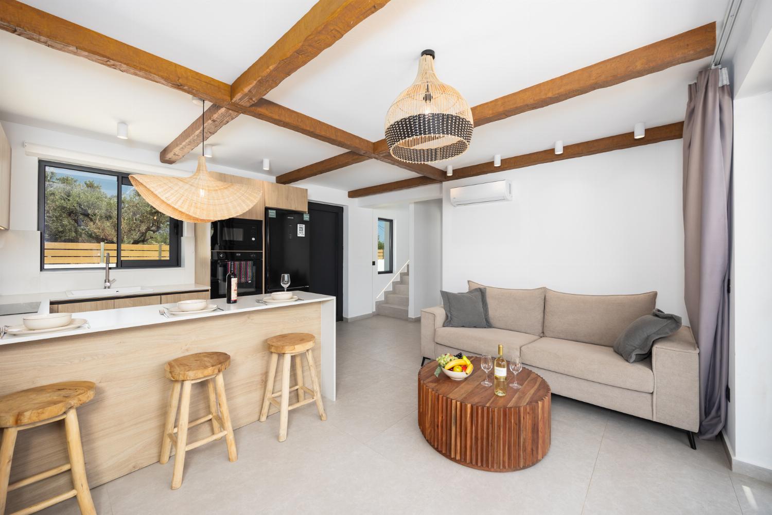Open-plan living room with sofa, breakfast bar, kitchen, A/C, WiFi internet, and satellite TV