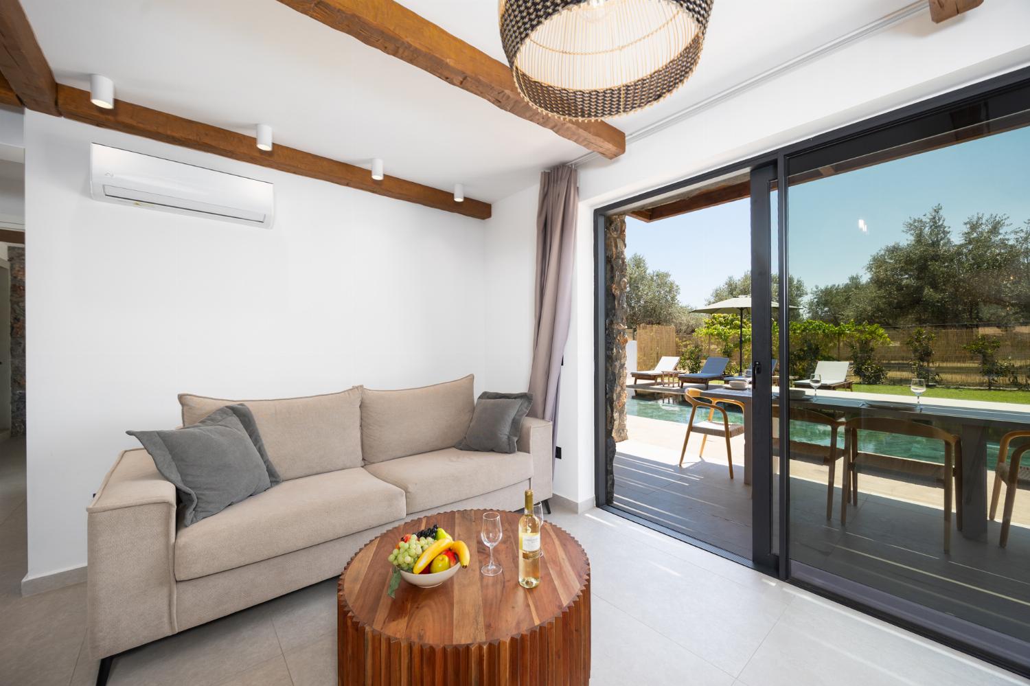Open-plan living room with sofa, breakfast bar, kitchen, A/C, WiFi internet, and satellite TV