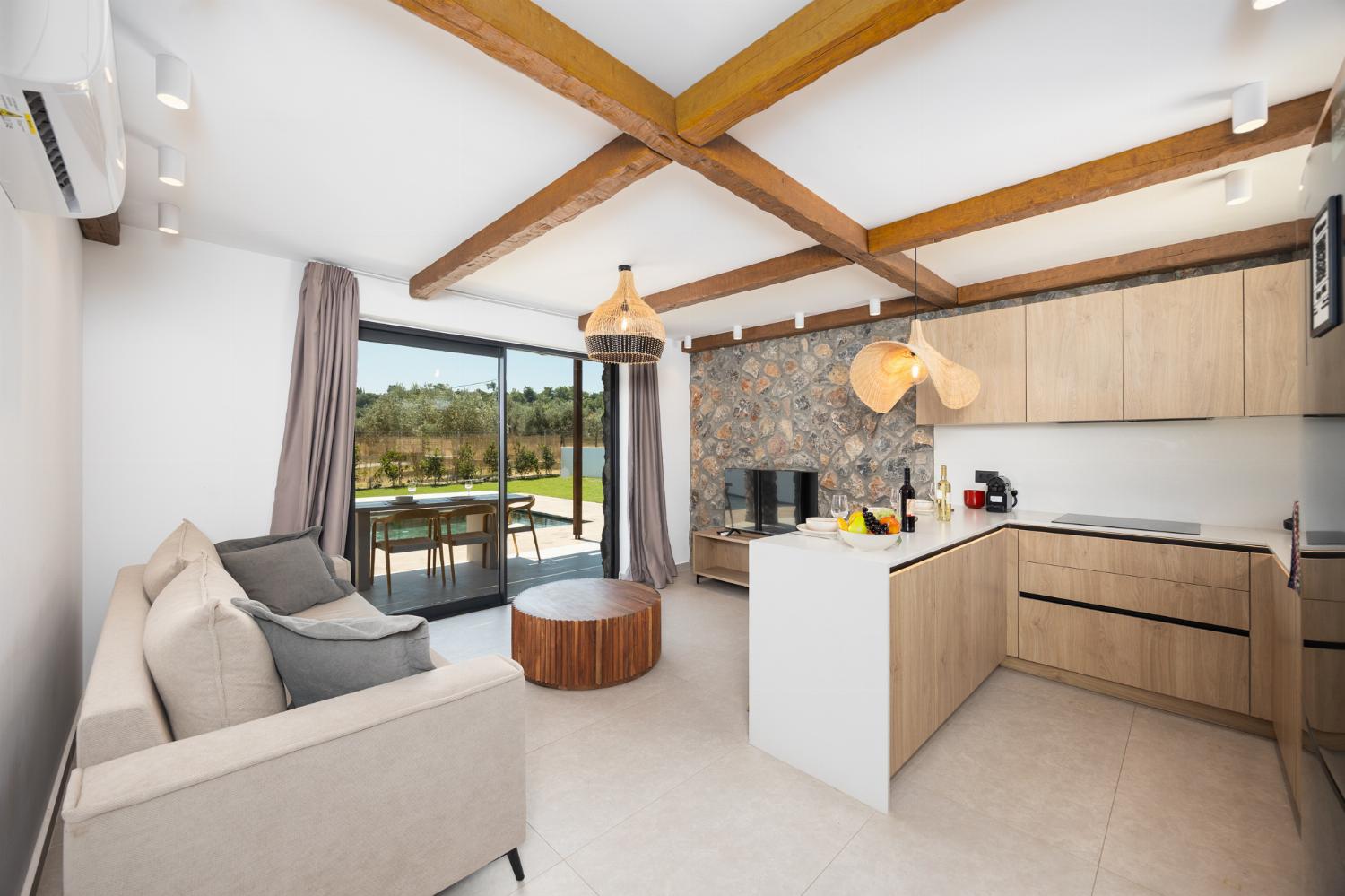 Open-plan living room with sofa, breakfast bar, kitchen, A/C, WiFi internet, and satellite TV