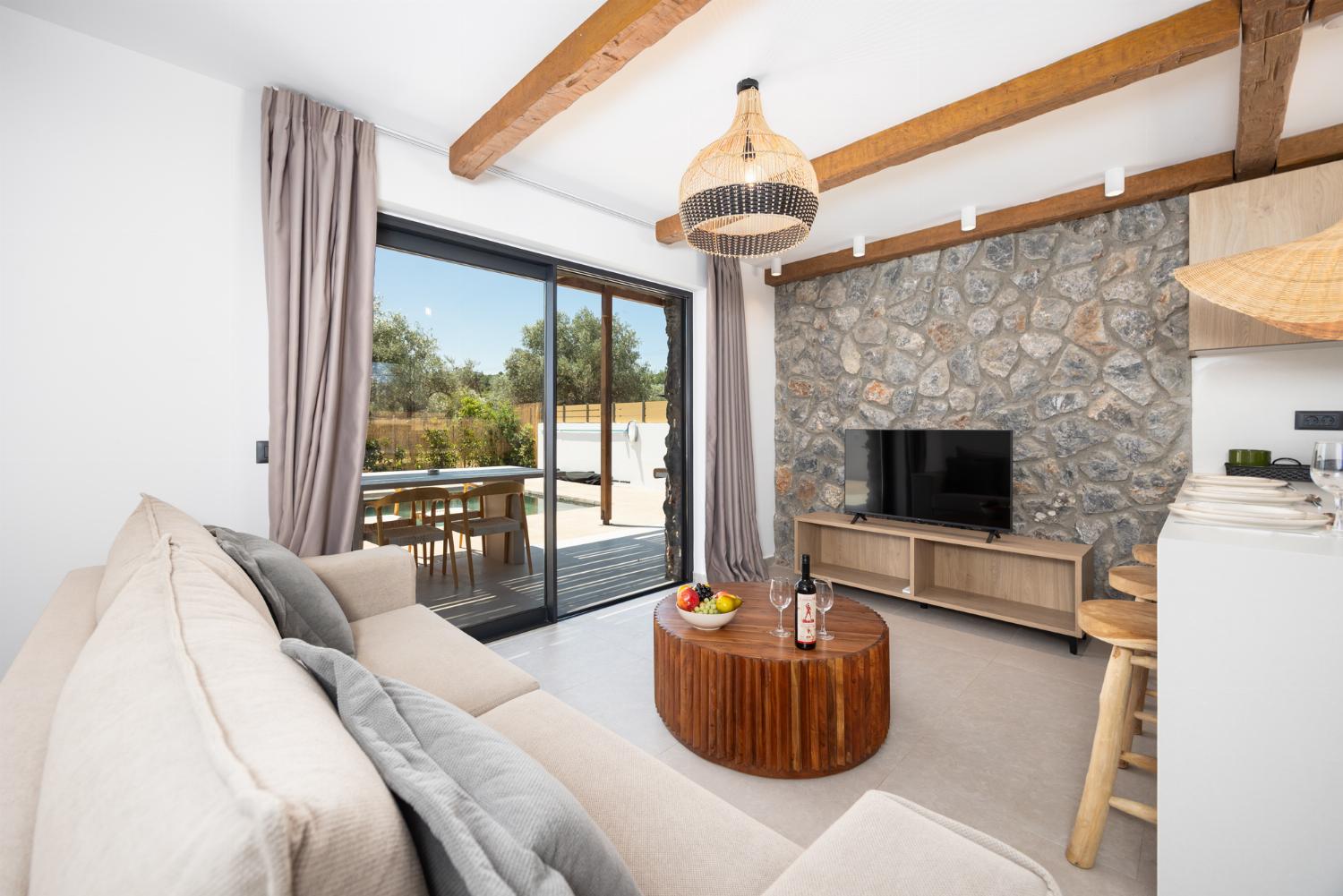 Open-plan living room with sofa, breakfast bar, kitchen, A/C, WiFi internet, and satellite TV