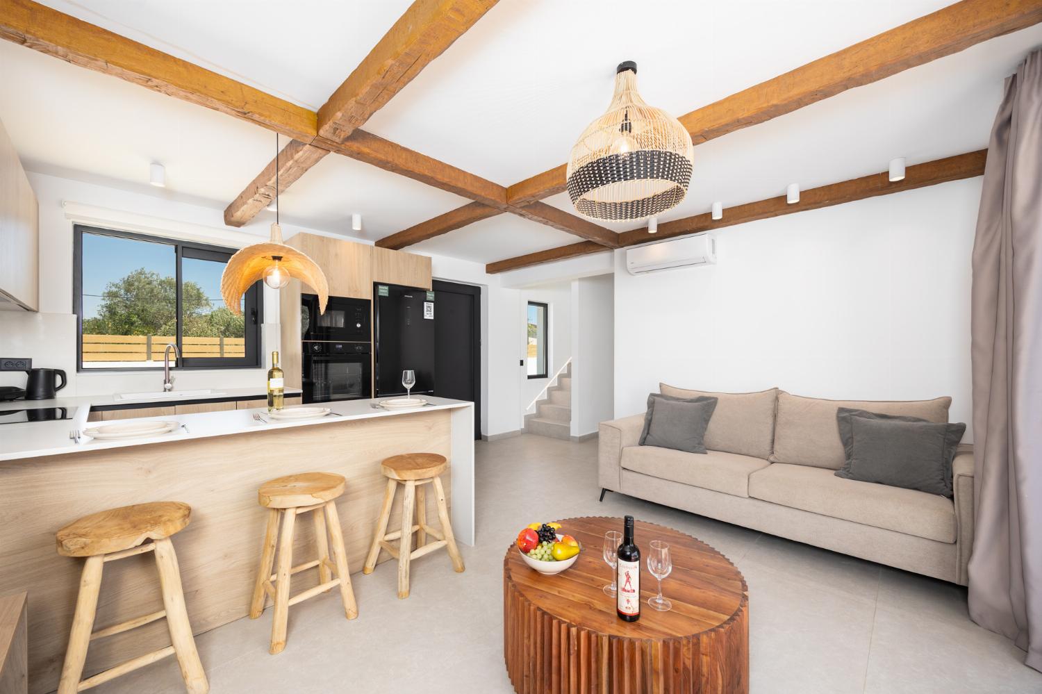 Open-plan living room with sofa, breakfast bar, kitchen, A/C, WiFi internet, and satellite TV