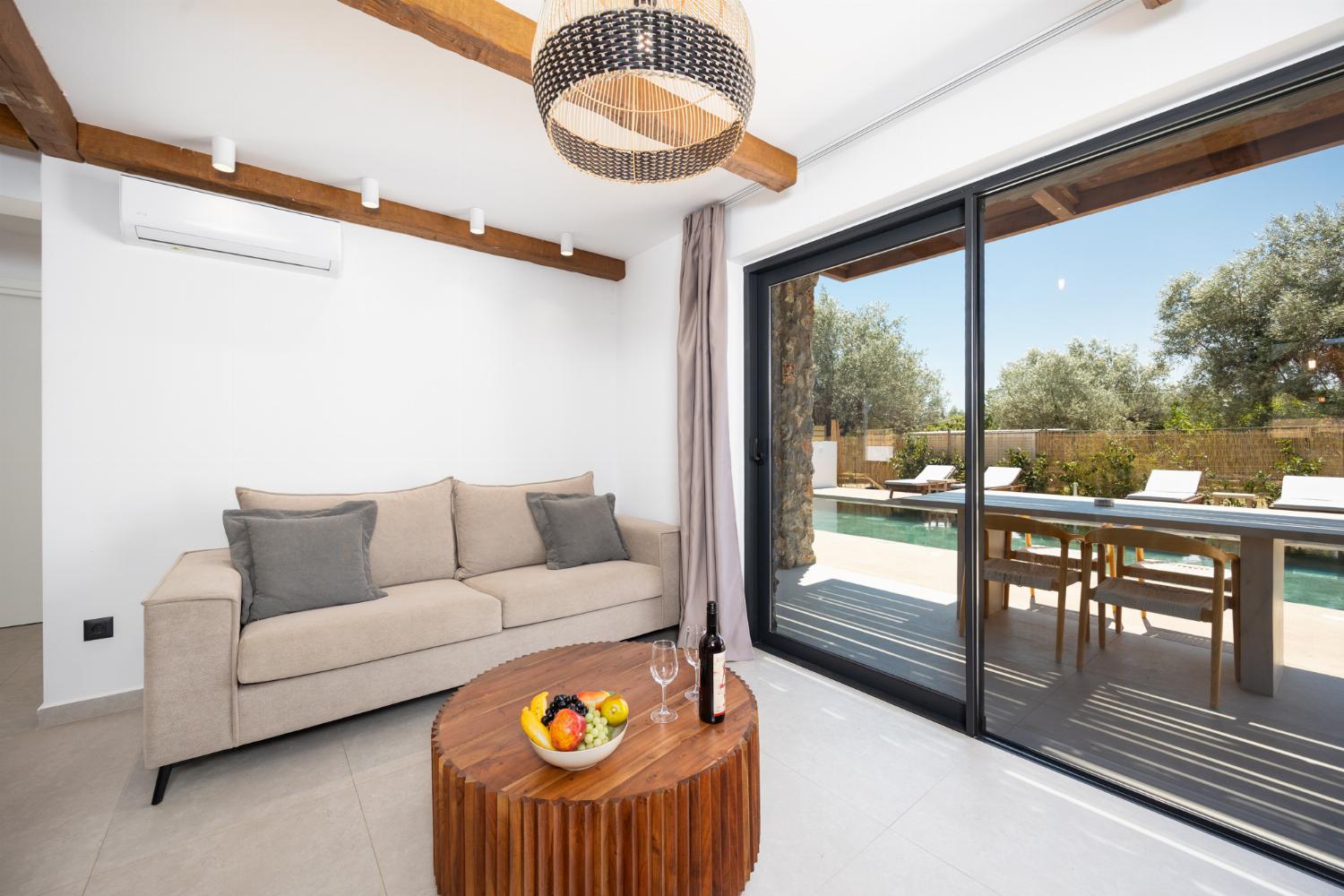 Open-plan living room with sofa, breakfast bar, kitchen, A/C, WiFi internet, and satellite TV