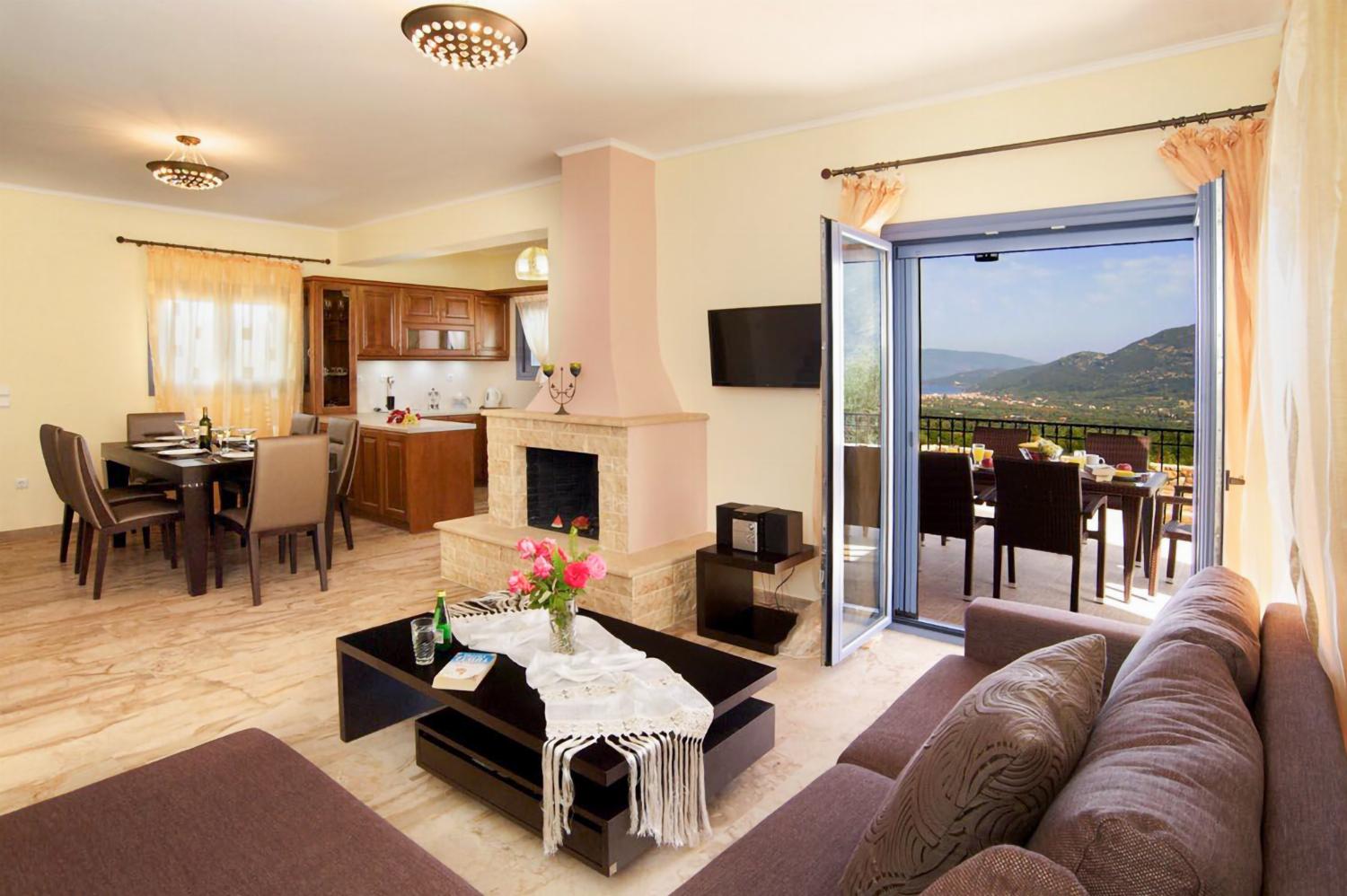 Open-plan living room with sofa, dining area, kitchen, ornamental fireplace, A/C, WiFi internet, and satellite TV