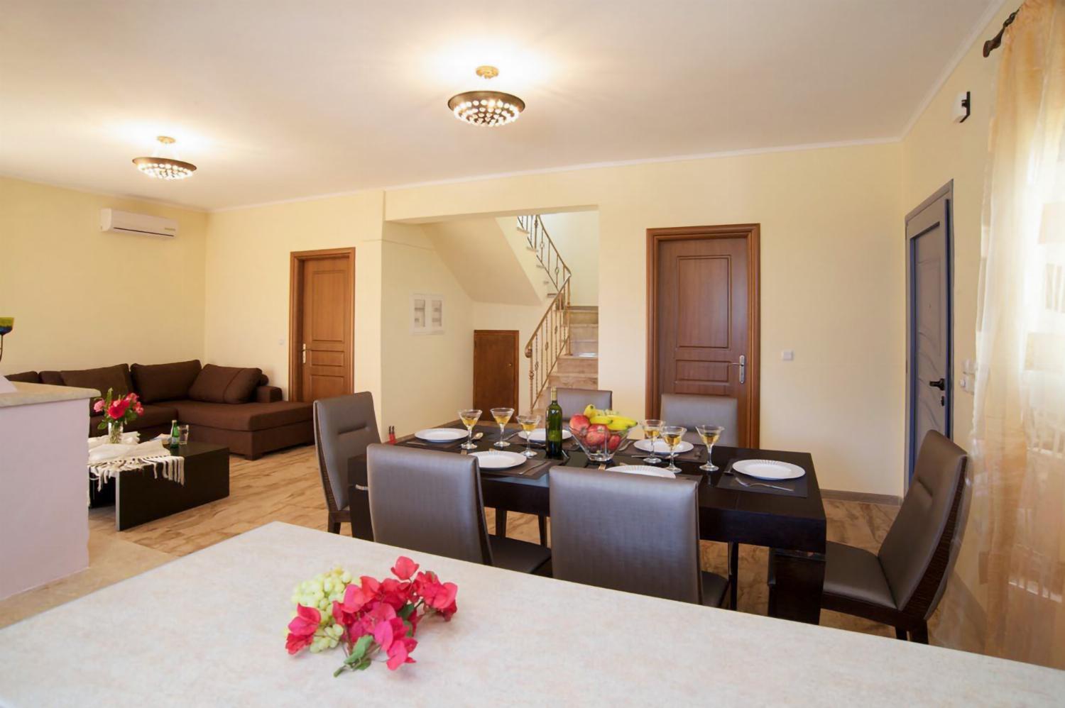 Open-plan living room with sofa, dining area kitchen, A/C, WiFi internet, and satellite TV