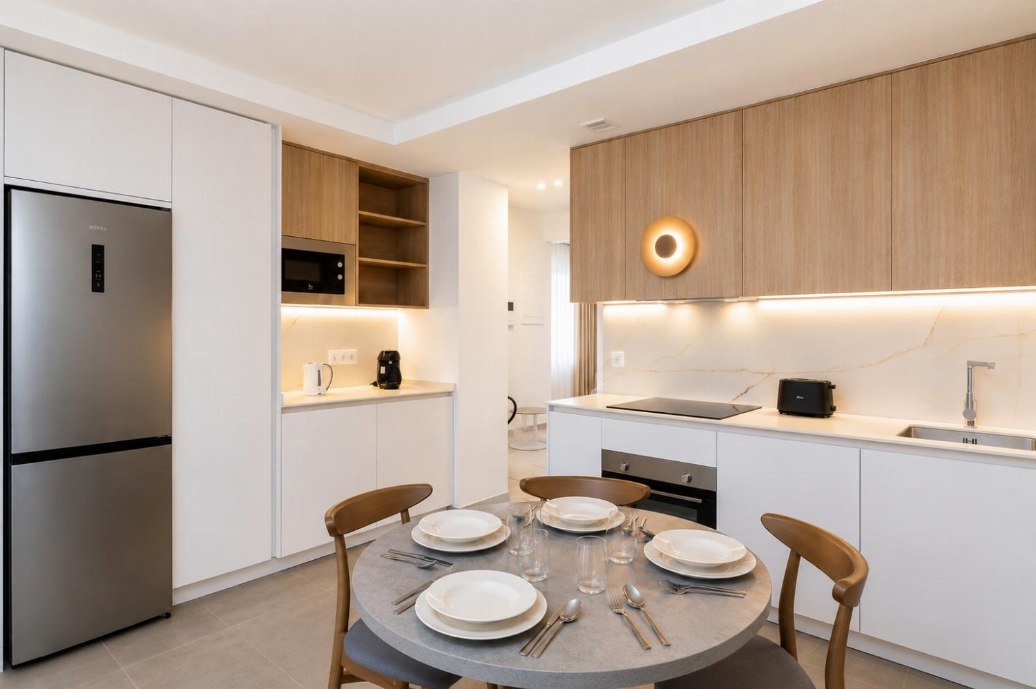 A bright modern open-plan living area with a stylish kitchen, dining space.