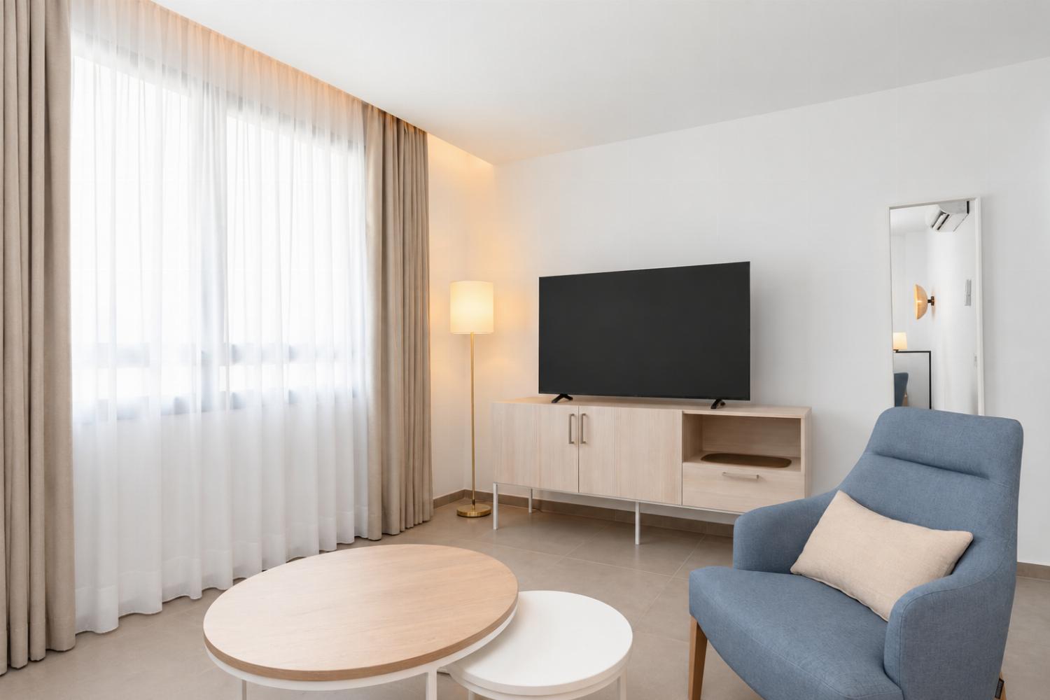 A modern open-plan living and dining area with elegant neutral decor.