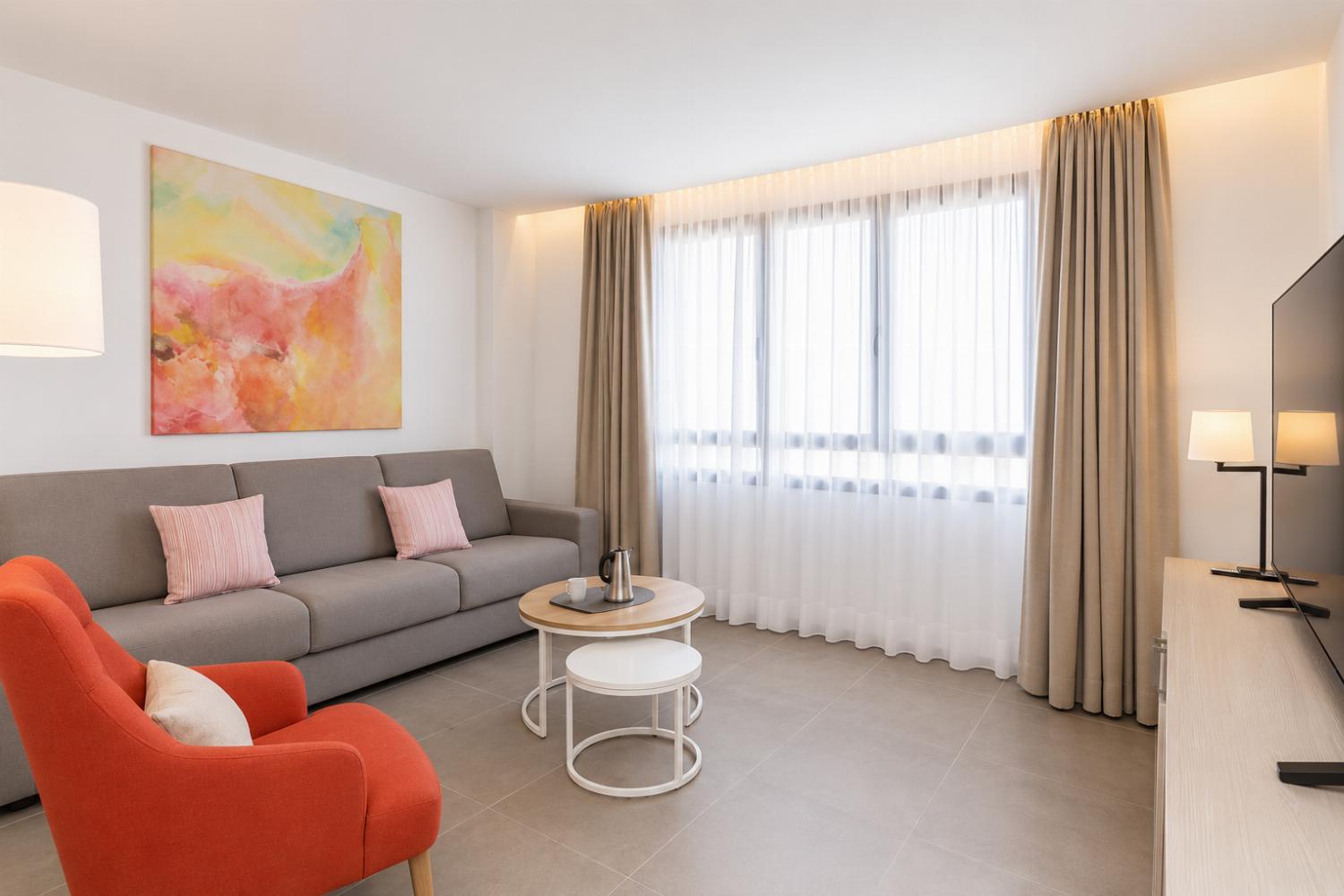A modern open-plan living and dining area with elegant neutral decor.