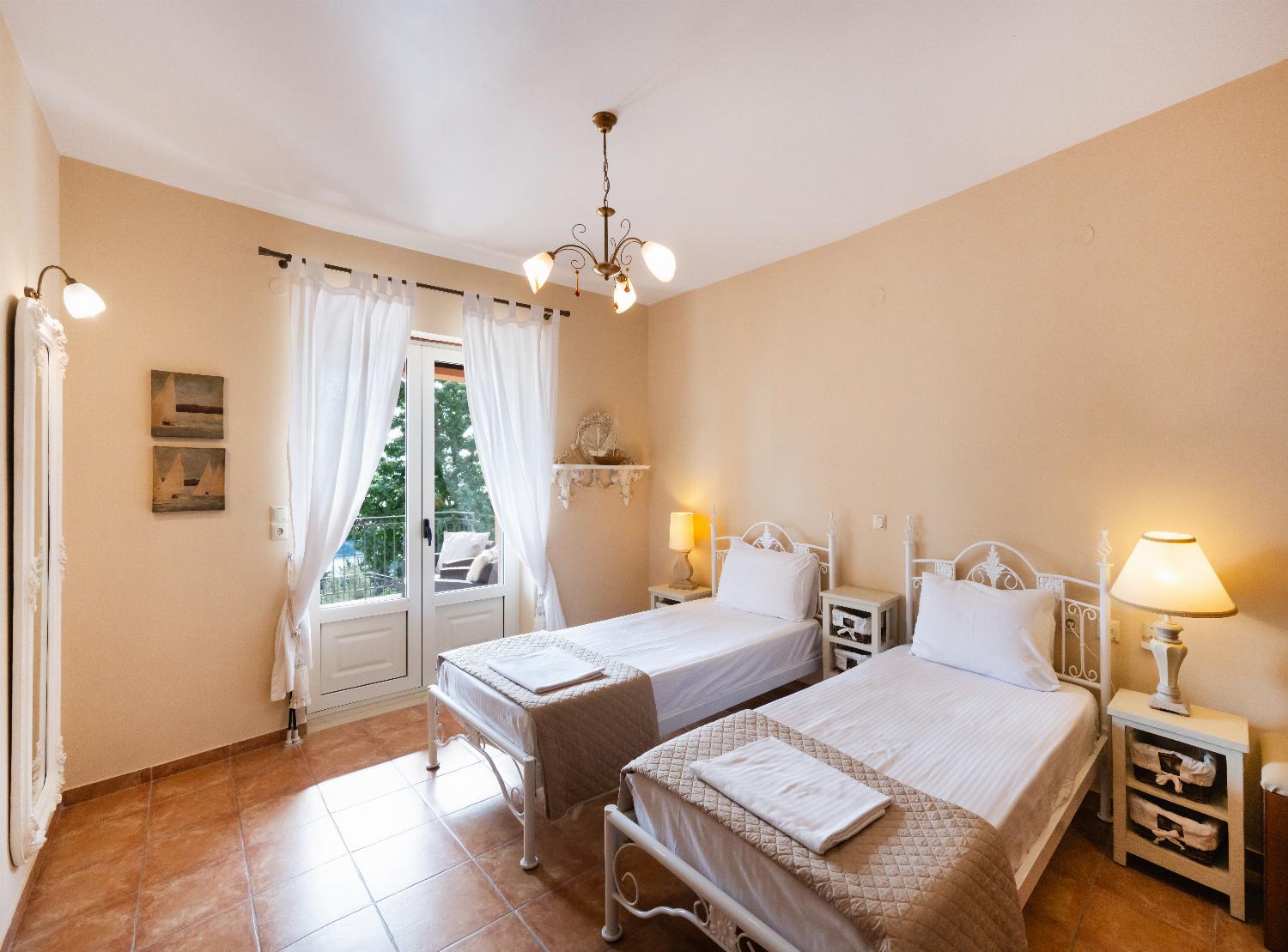 Twin bedroom featuring ornate white metal frames and balcony doors.