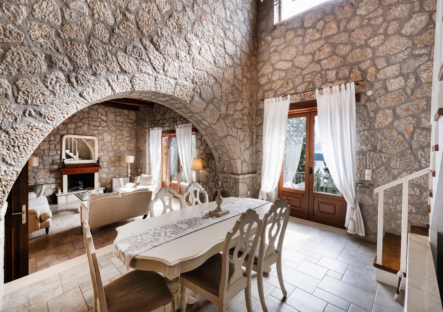 Stone archway framing a formal dining table and cozy living area